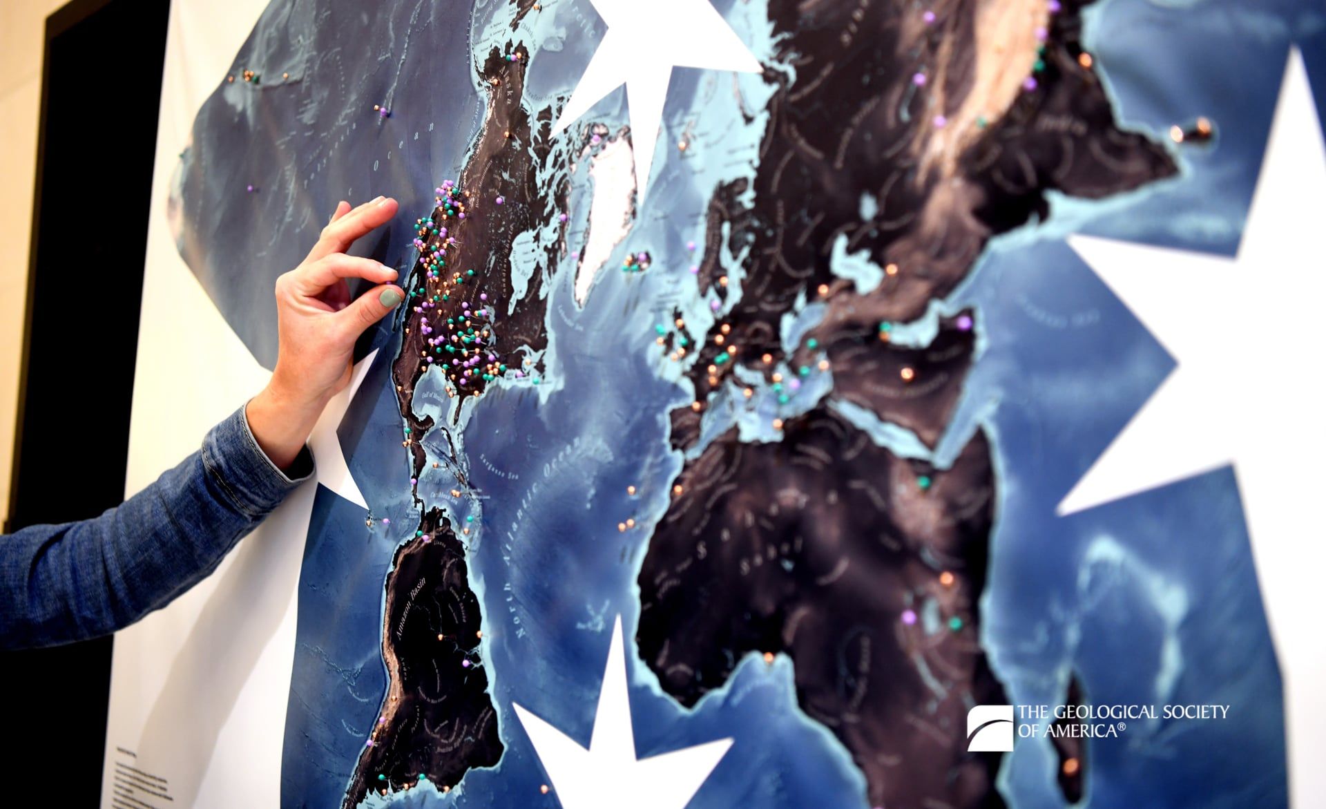 A Connects 2025 attendee places a pin the Baja California section of a world map projection to indicate their favorite geologic site.