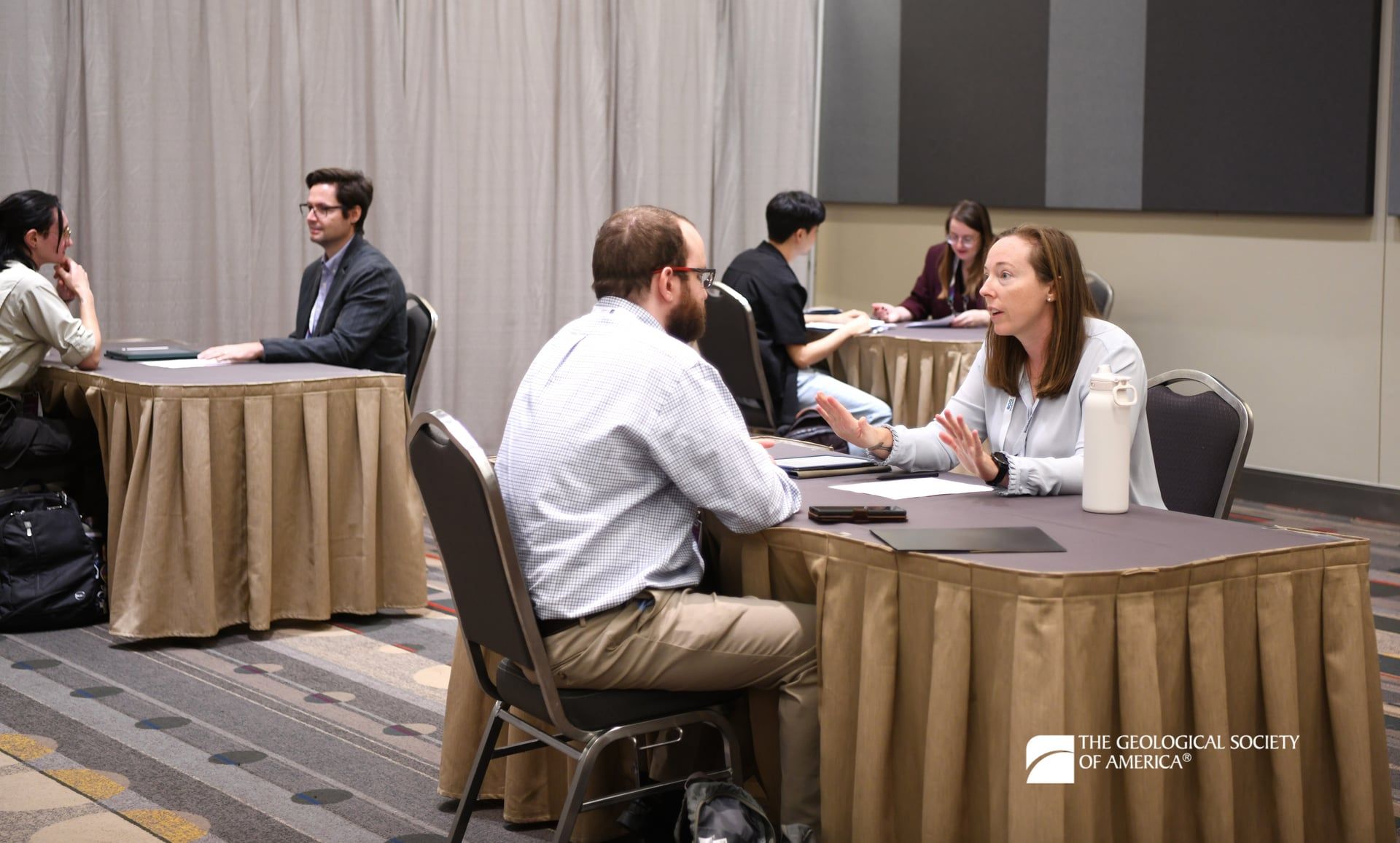 Three sets of GSA Connects 2025 mentors and mentees are seated at individual tables in the GeoCareers Corner.