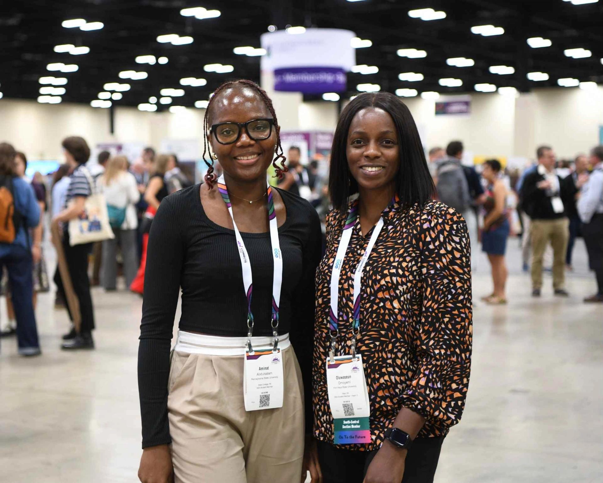 Meeting attendees posing for photo together in front of busy exhibit hall at GSA Connects meeting
