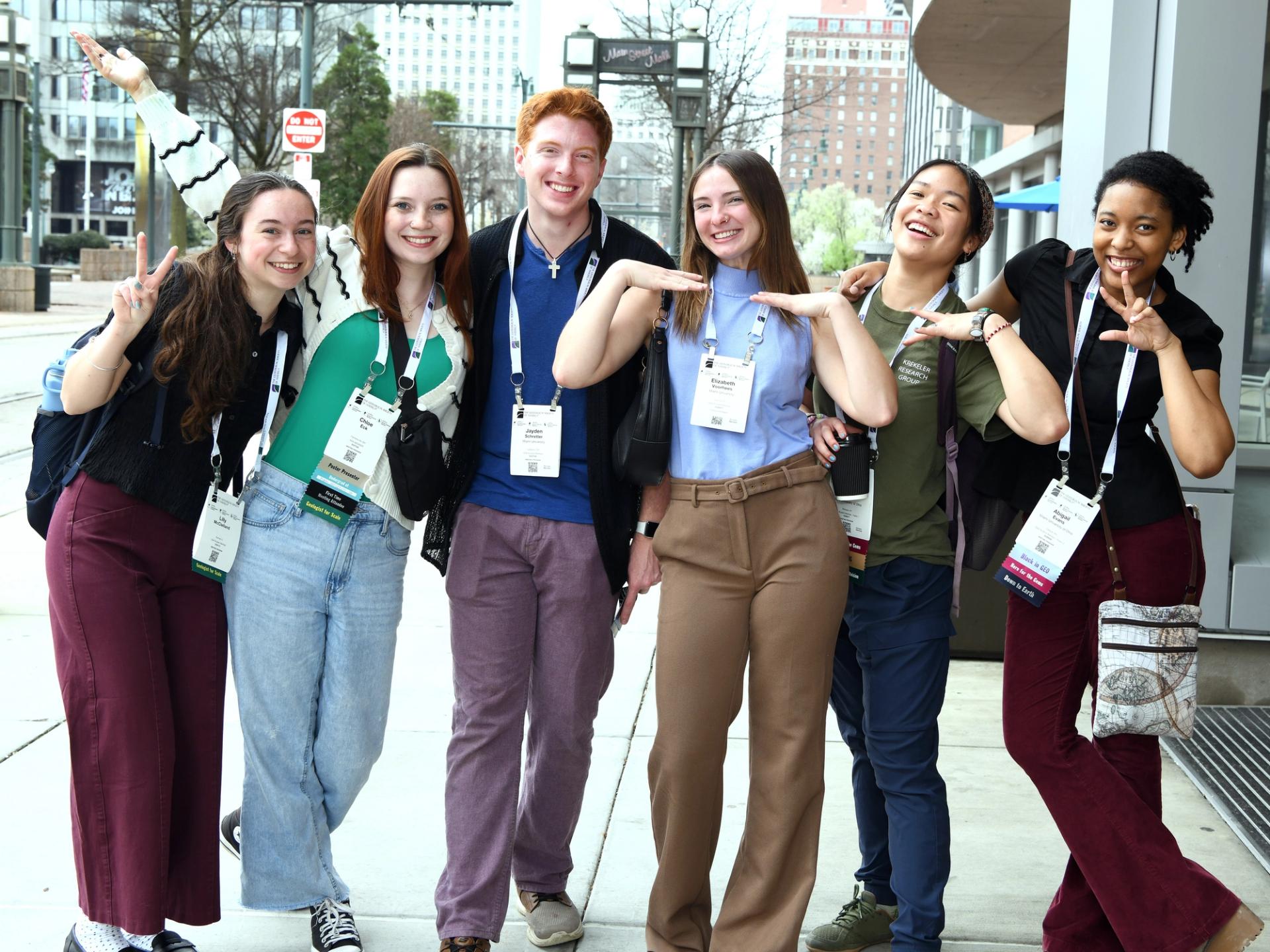 Young GSA conference attendees likely students posing together outside in front of conference center