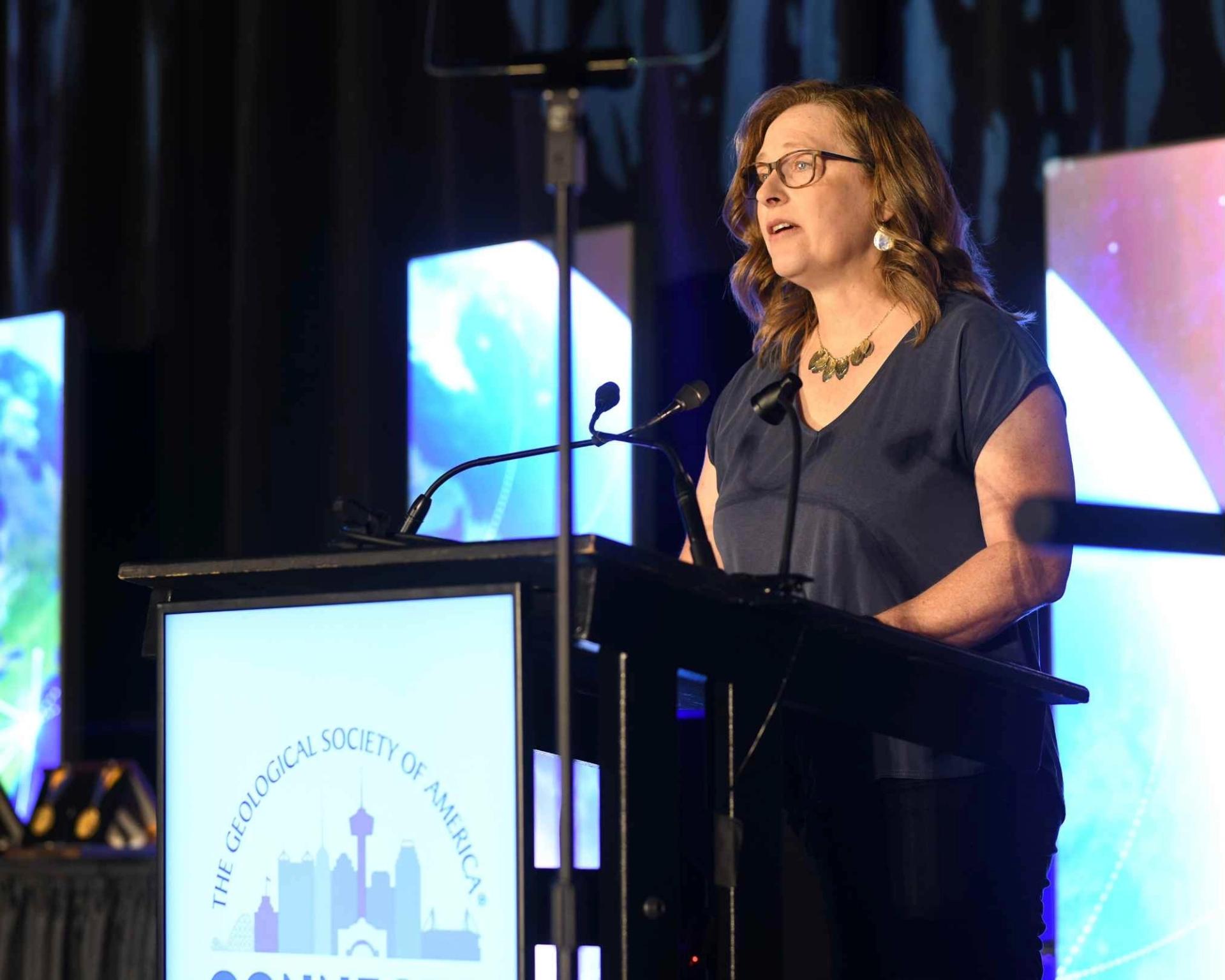 Woman awardee speaking on stage at GSA connects 2025