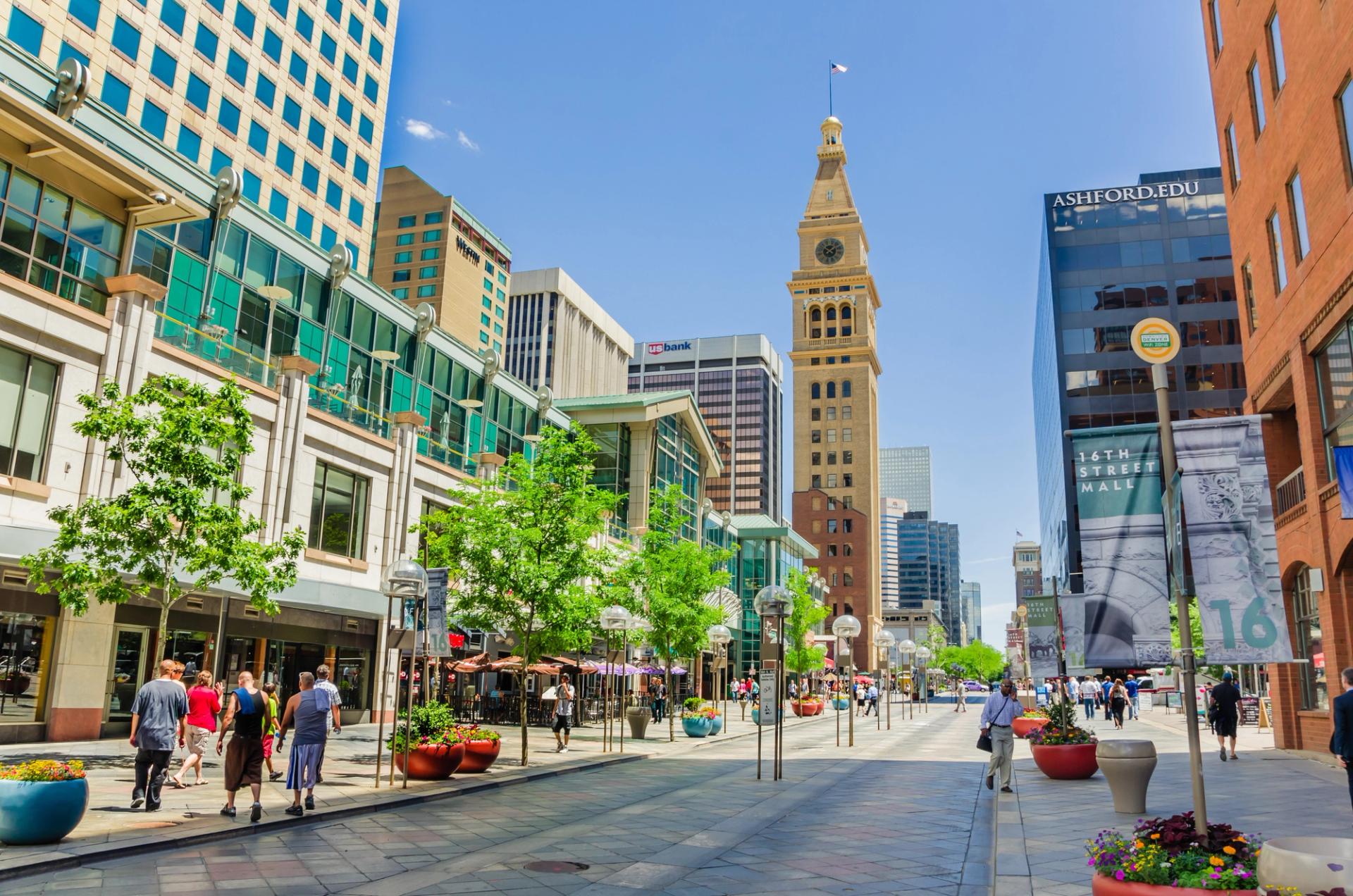 People wandering around the shops and restaurant of 16th street pedestrian mall in downtown Denver. Free electric shuttle buses cruise the mile-long mall every few minutes and make everything in downtown easy to reach.