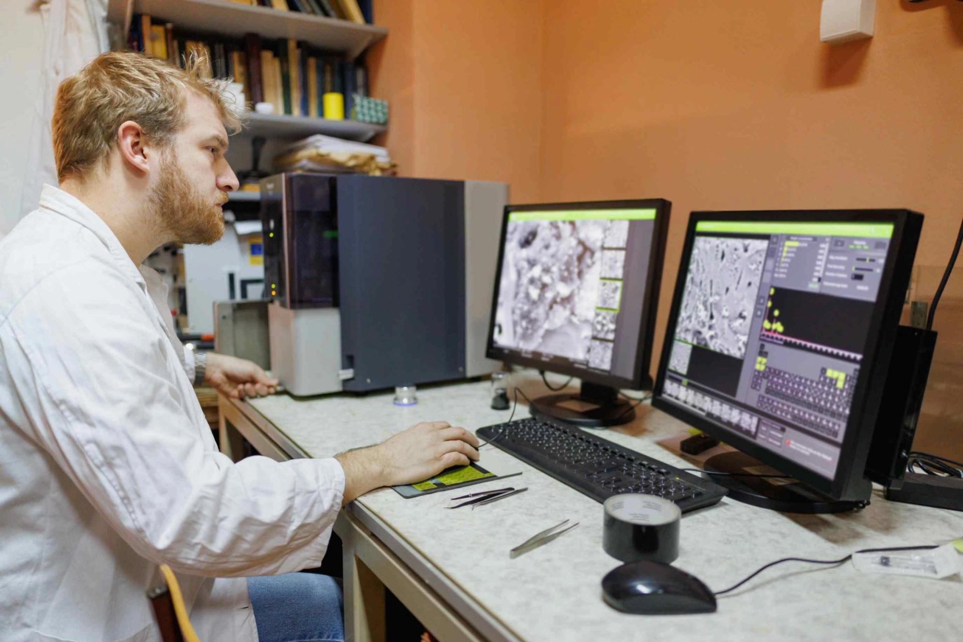 Image of scientist analyzing micoscopic data on computer