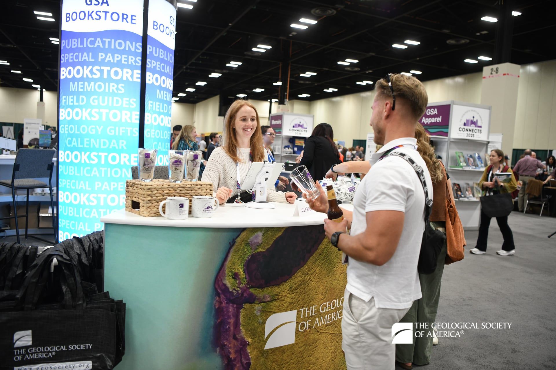 A conference attendee works with an employee at a booth.