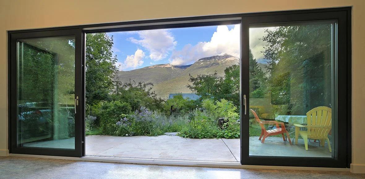 Large sliding glass opening connecting a mountain home to its patio