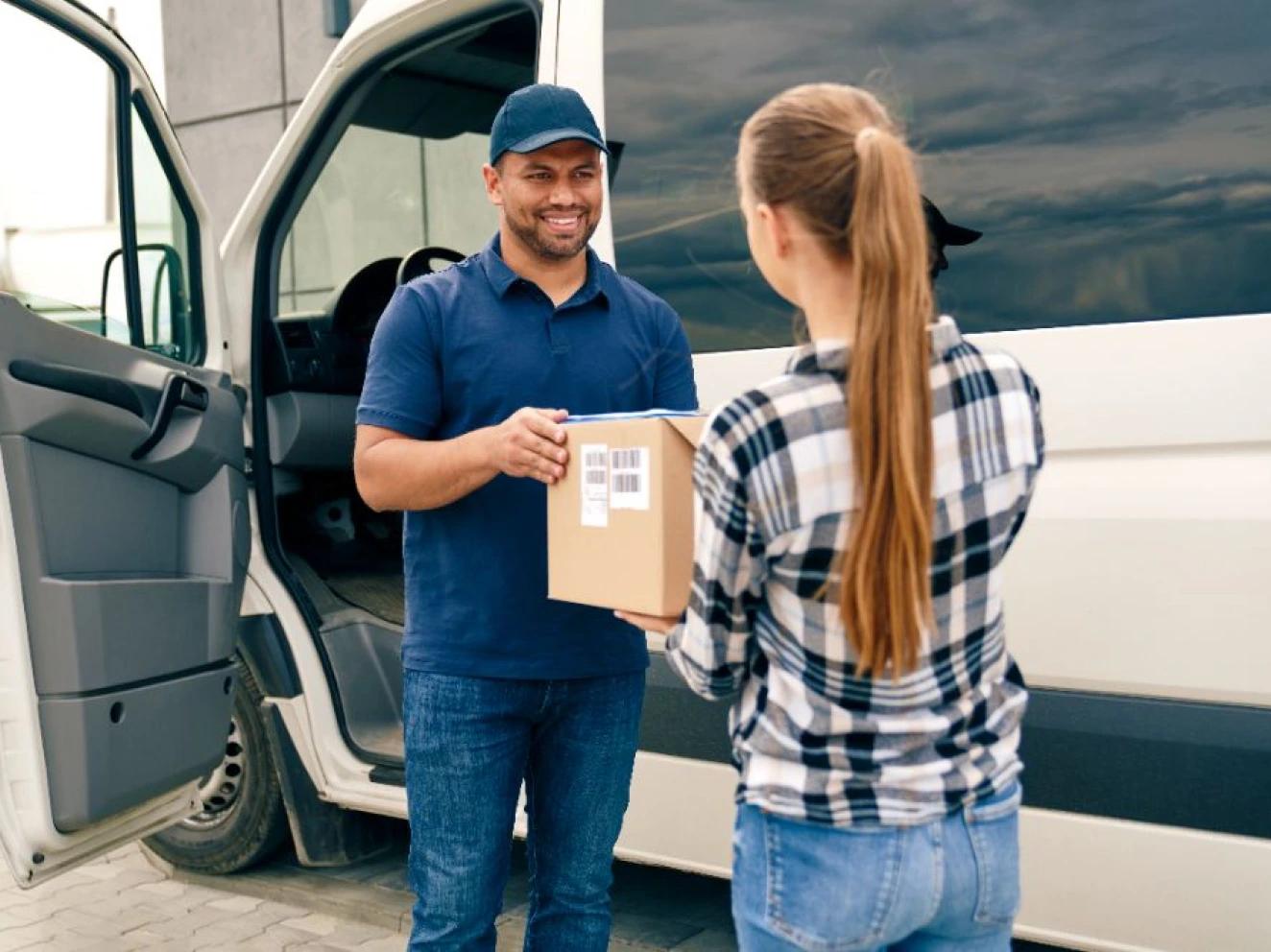 A courier handing a boxed laptop to a customer at the door