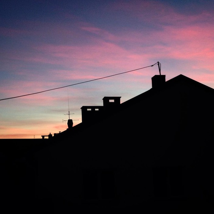 Rooftops silhouetted against the sunset.