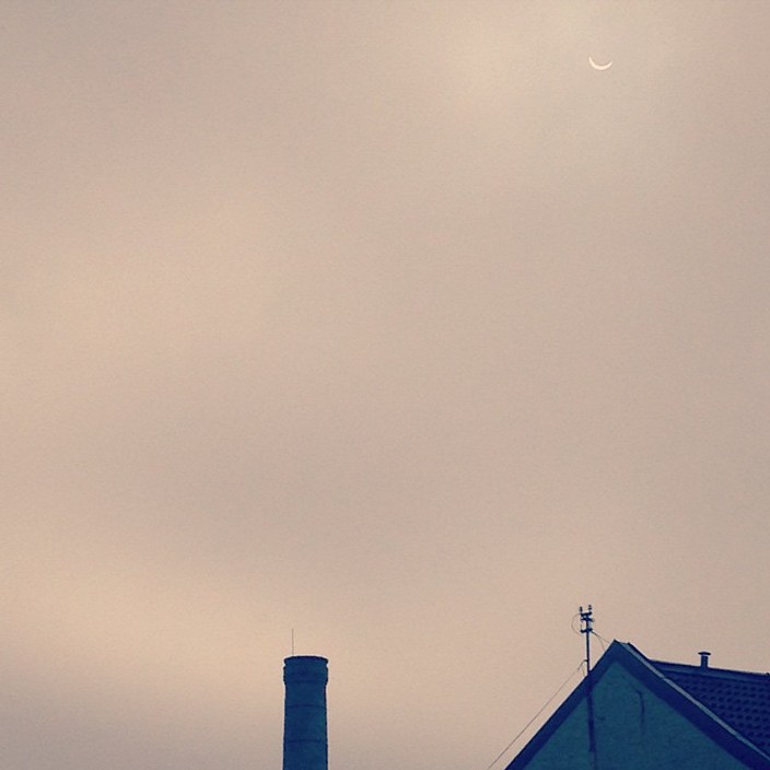 Partial solar eclipse visible through cloud cover