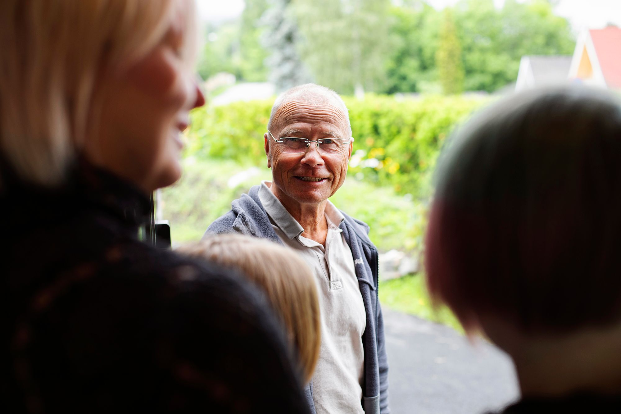 Familiekontakt i døråpning og mor med to sønner med ryggen til.