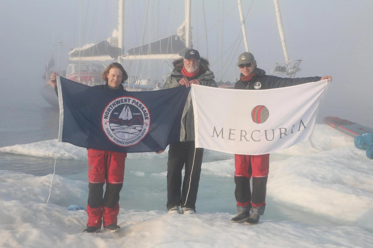 Alex Rockström, Keith Tuffley, and Isak Rockström hold the expedition and Mercuria flags. Credit: Keith Tuffley