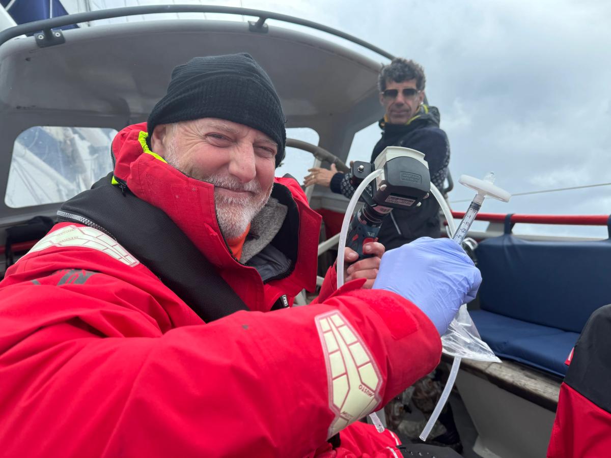 Keith Tuffley taking an eDNA sample from the waters of Disko Bay with NatureMetrics kit