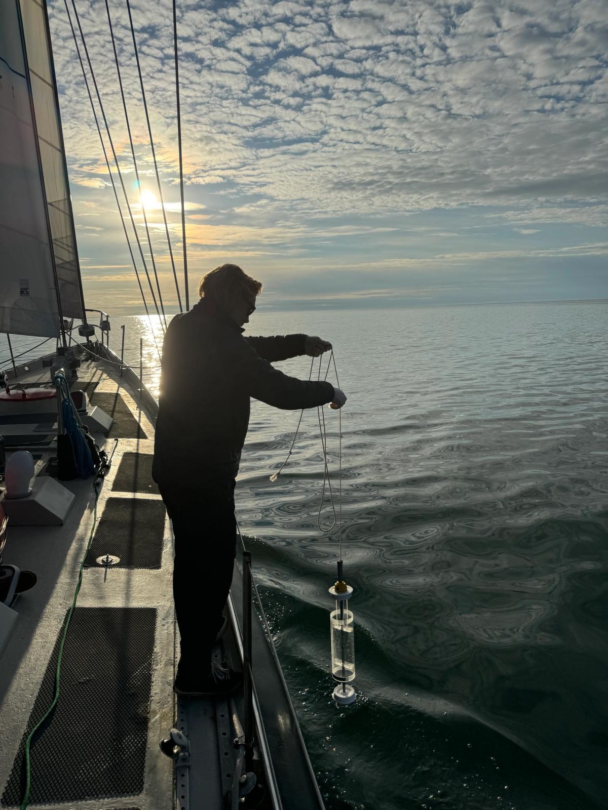 Alex Rockström collects a water sample from the ocean, from which eDNA will be extracted using a special filter. Credit: Keith Tuffley