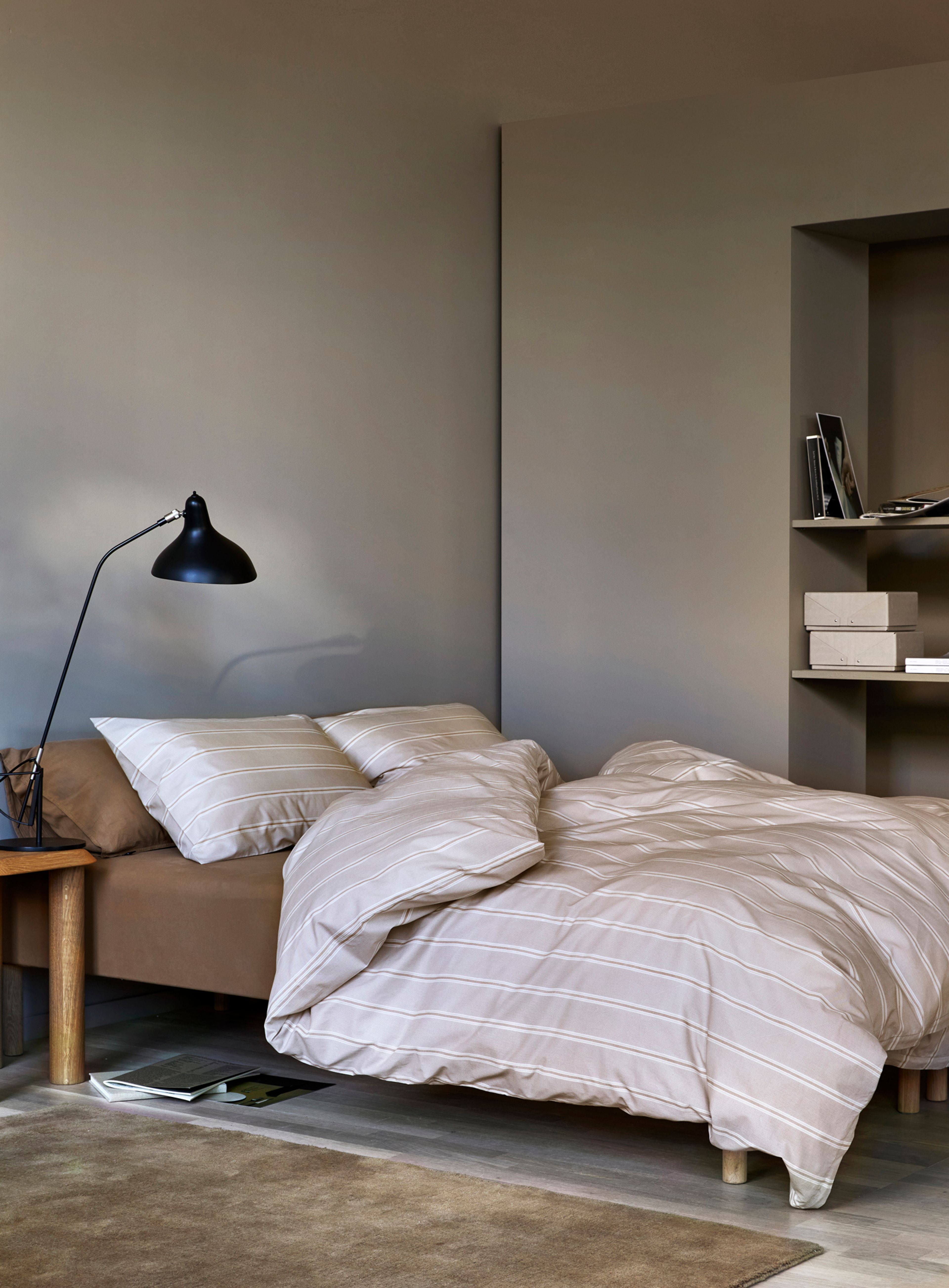 "Oppredd seng med Høie Tor sengesett i klar rosa – en frisk miks av smalstripet og ensfarget design i myk bomull, kombinert med laken og hotellputetrekk i steinvasket bomull for et avslappet og helhetlig uttrykk.