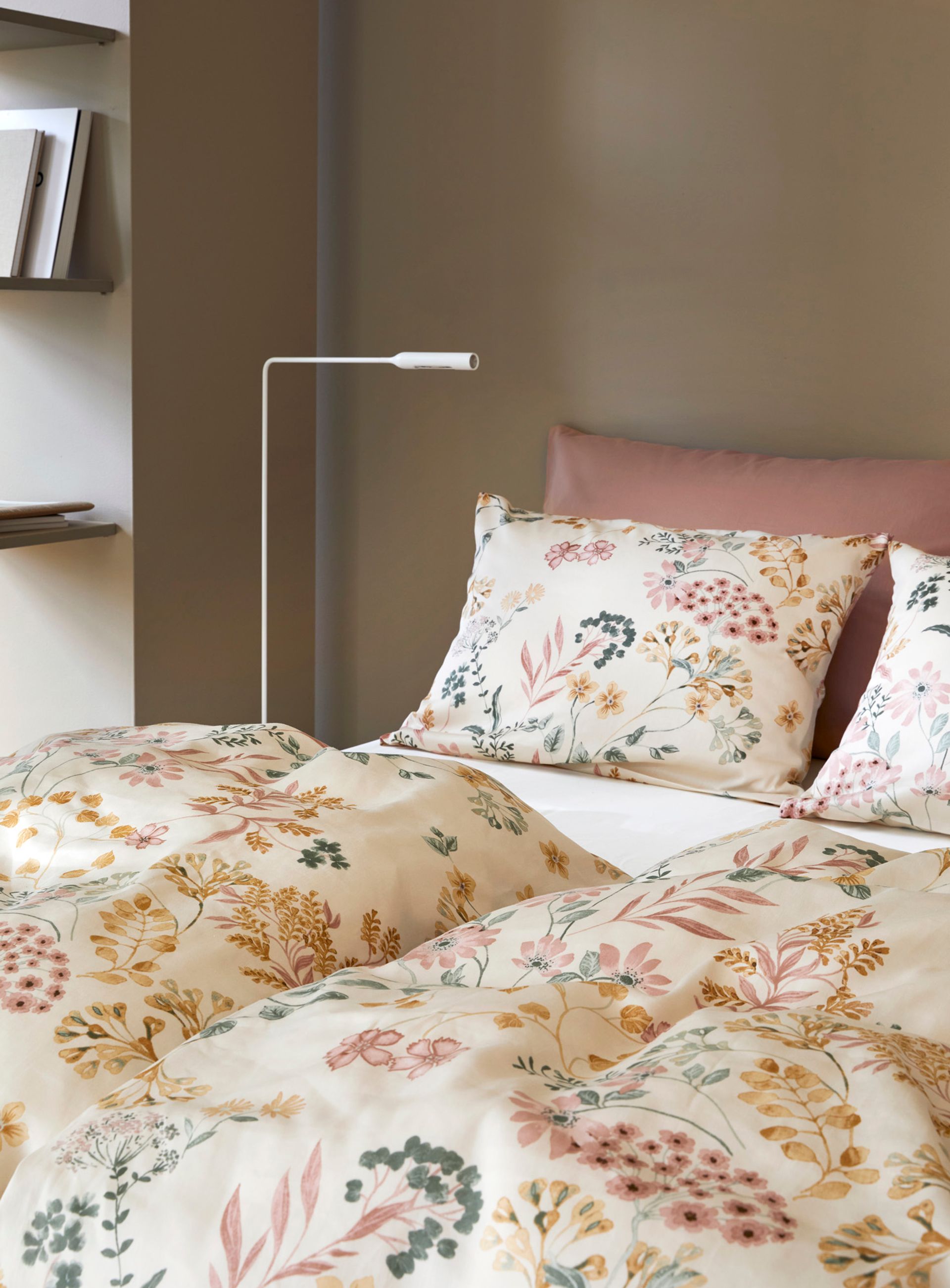 Nærbilde av oppredd seng med Høie Tor og Frøya sengesett i beige – en avslappet miks av smale striper og ensfarget bomull, som skaper en rolig og lun atmosfære på soverommet.