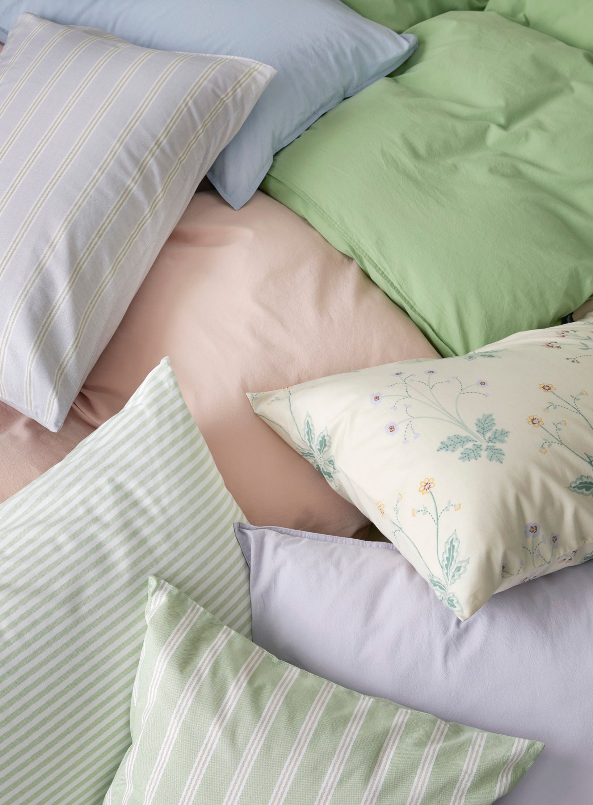 Seng oppredd med Høie Tor og Frøya sengesett i lyseblå nyanser – en miks av ensfarget og stripete design skaper et rolig og gjennomført uttrykk i soverommet.