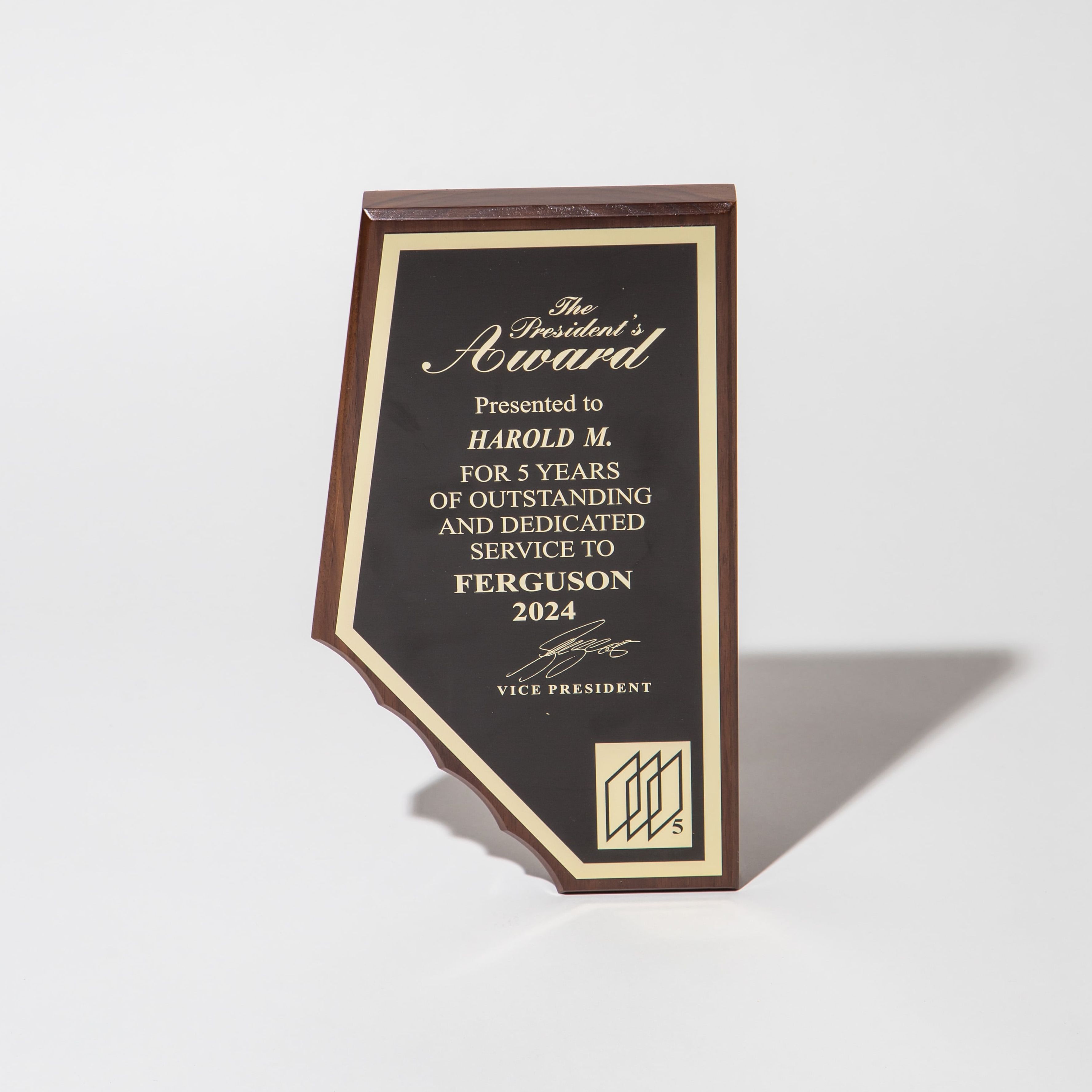 Wooden plaque with gold lettering for the President's Award, honoring 5 years of service in 2024.