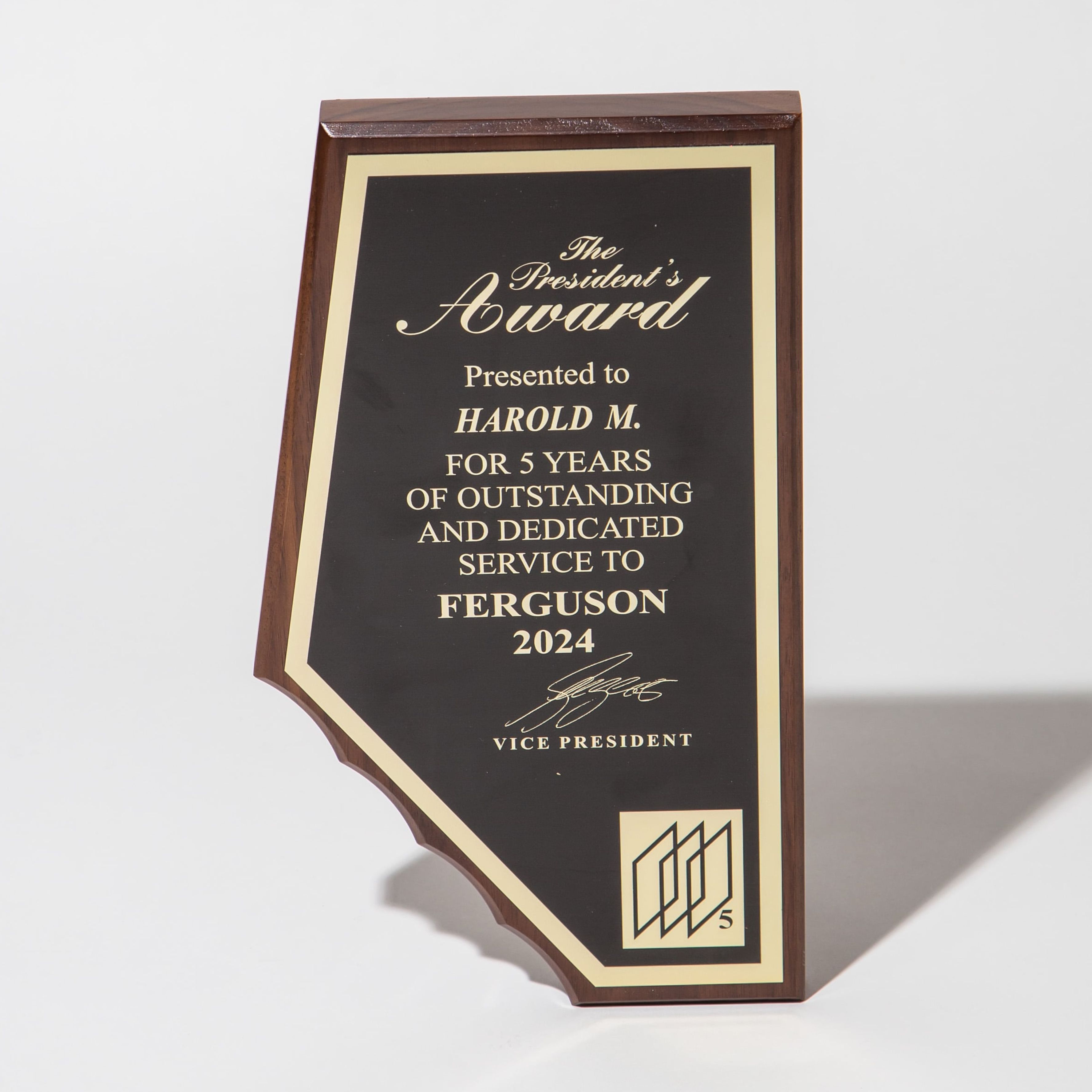 Wooden plaque with gold lettering for the President's Award, honoring 5 years of service in 2024.