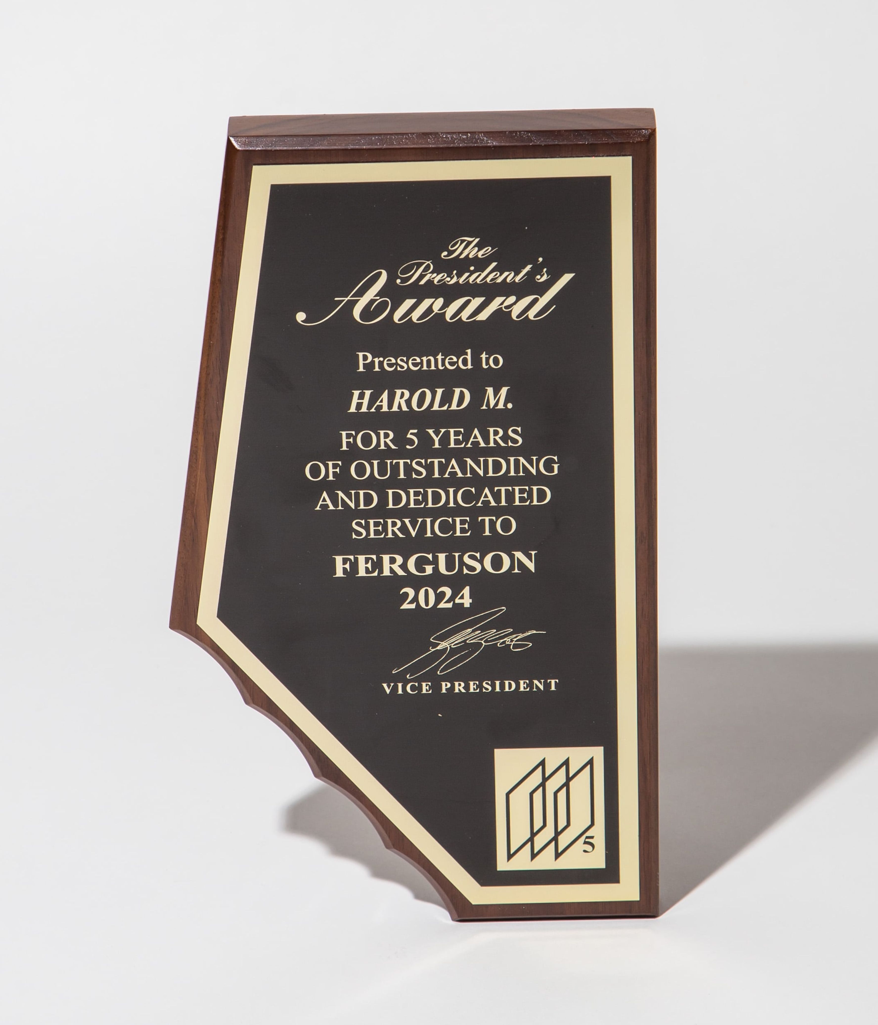 Wooden plaque with gold lettering for the President's Award, honoring 5 years of service in 2024.