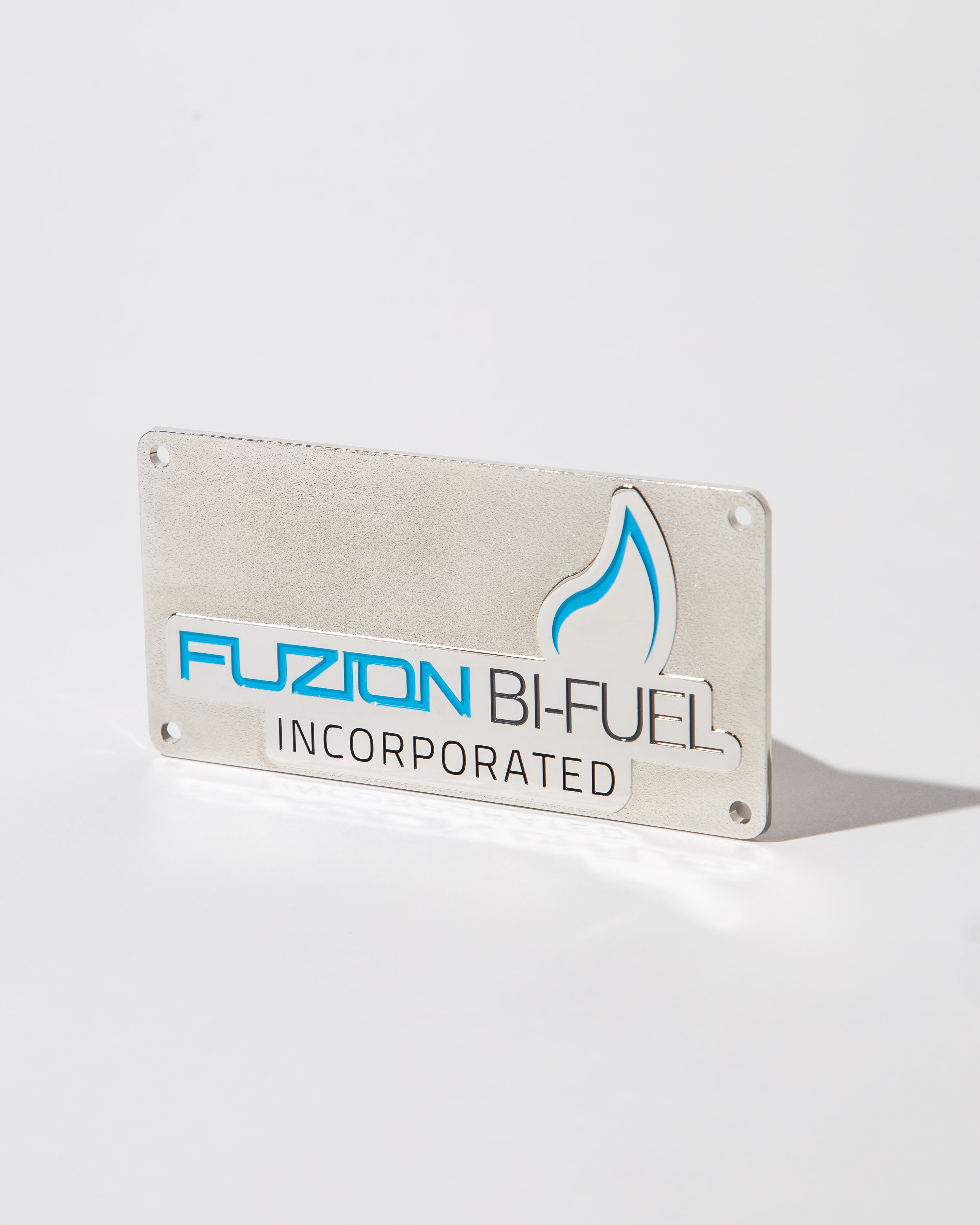 Metal sign with 'Fuzion Bi-Fuel Incorporated' and a blue flame logo on a white background.