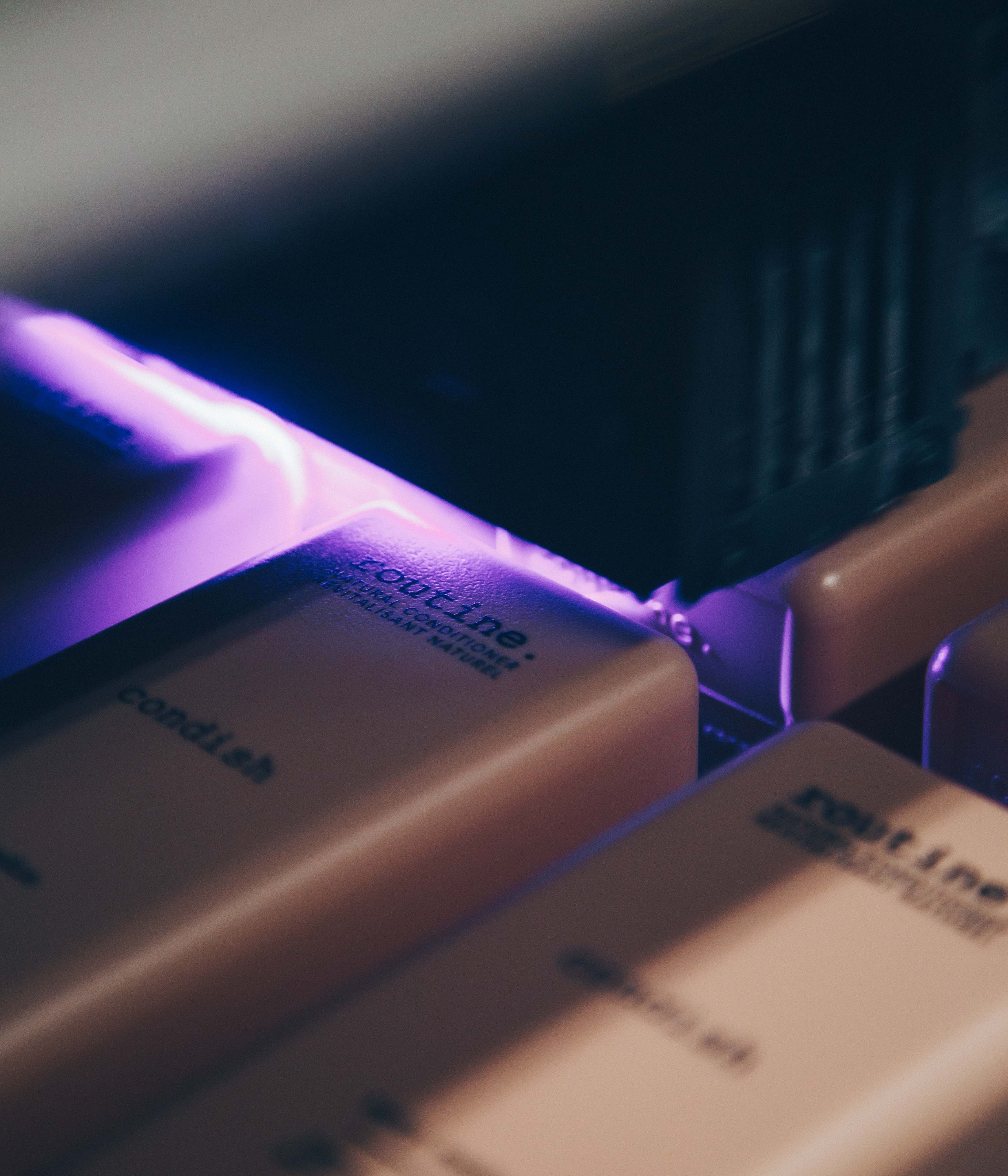Close up of a digital printer printing a label on a Routine-branded shampoo bottle