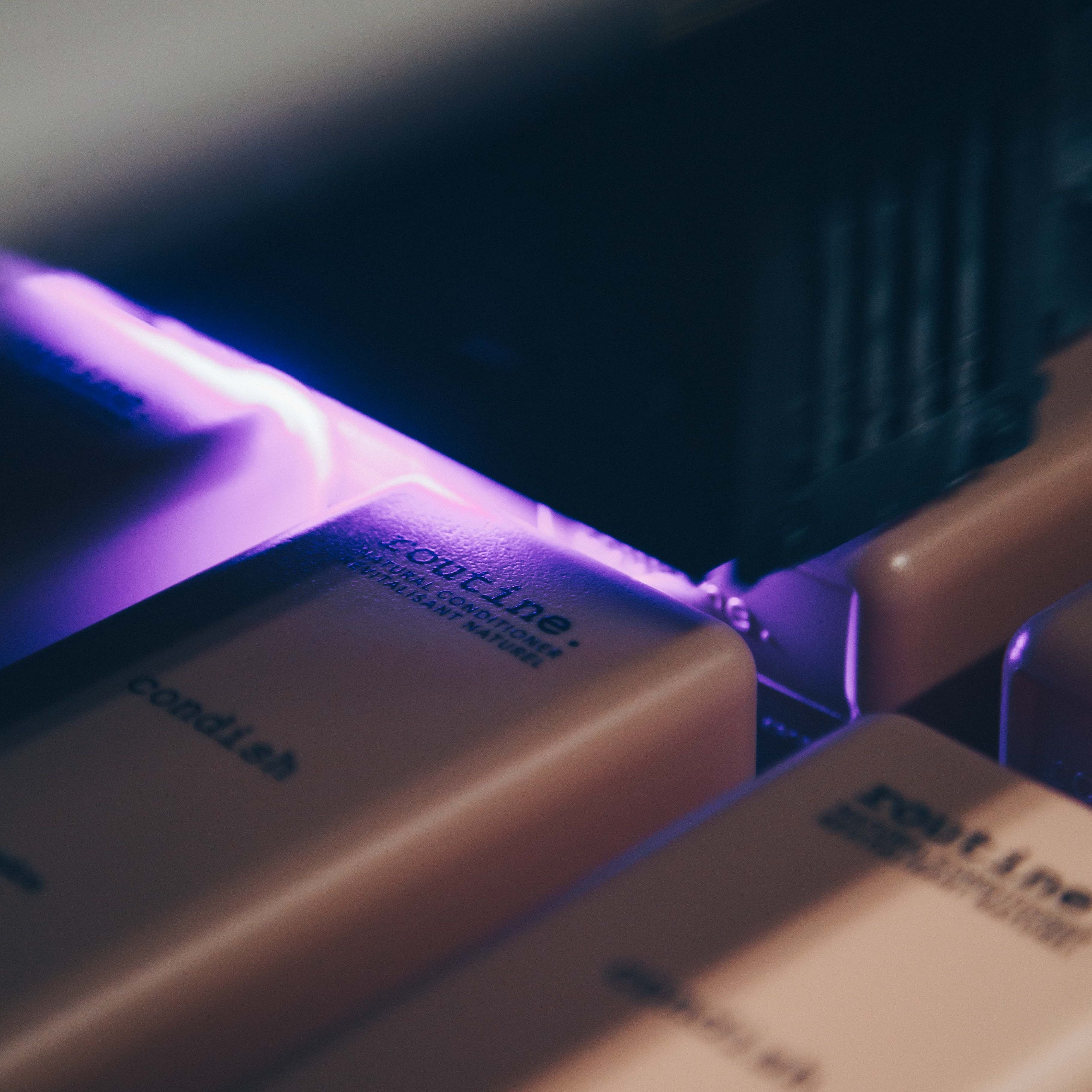 Close up of a digital printer printing a label on a Routine-branded shampoo bottle
