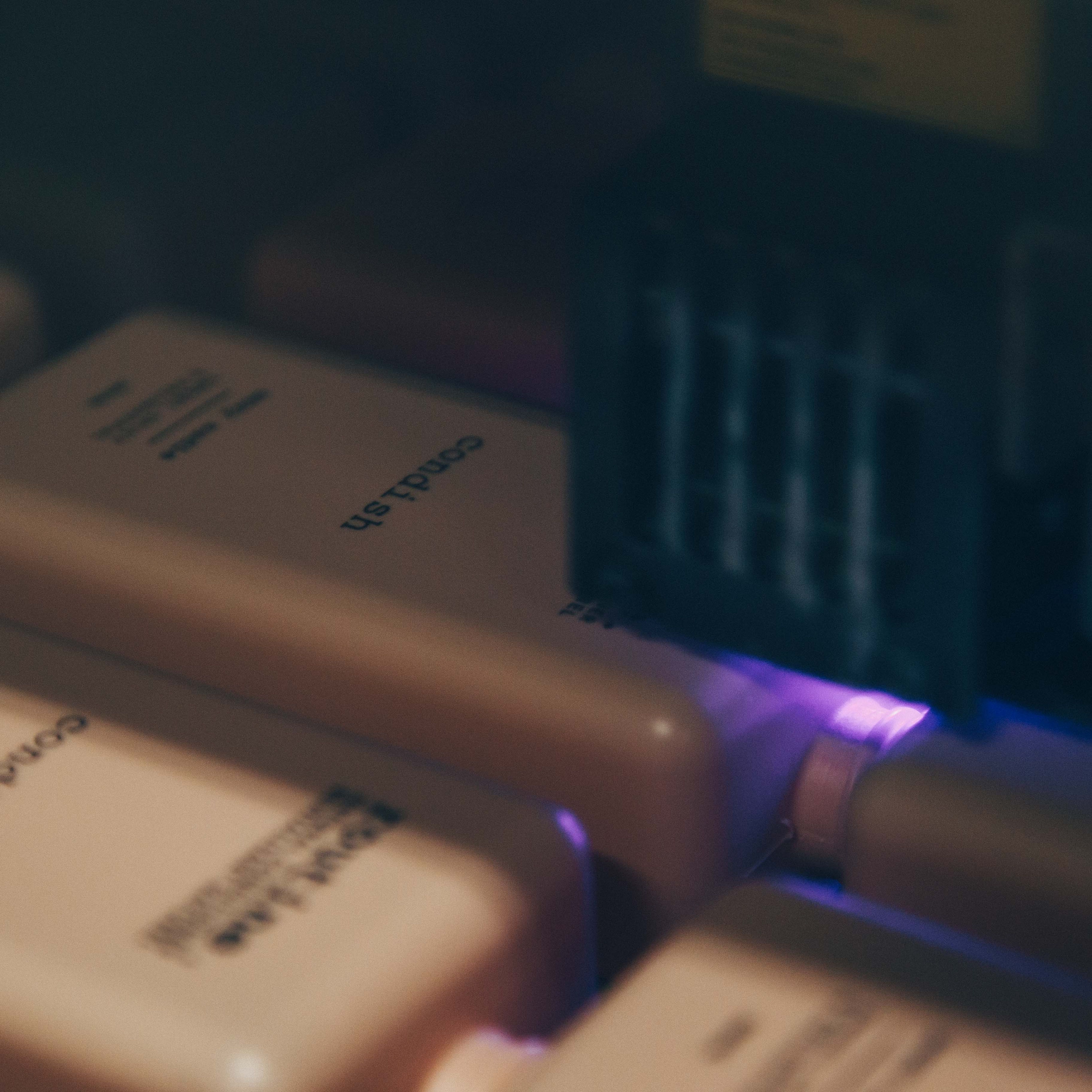 A close-up of a digital printing device printing labels on shampoo bottles for Routine Natural Conditioner.