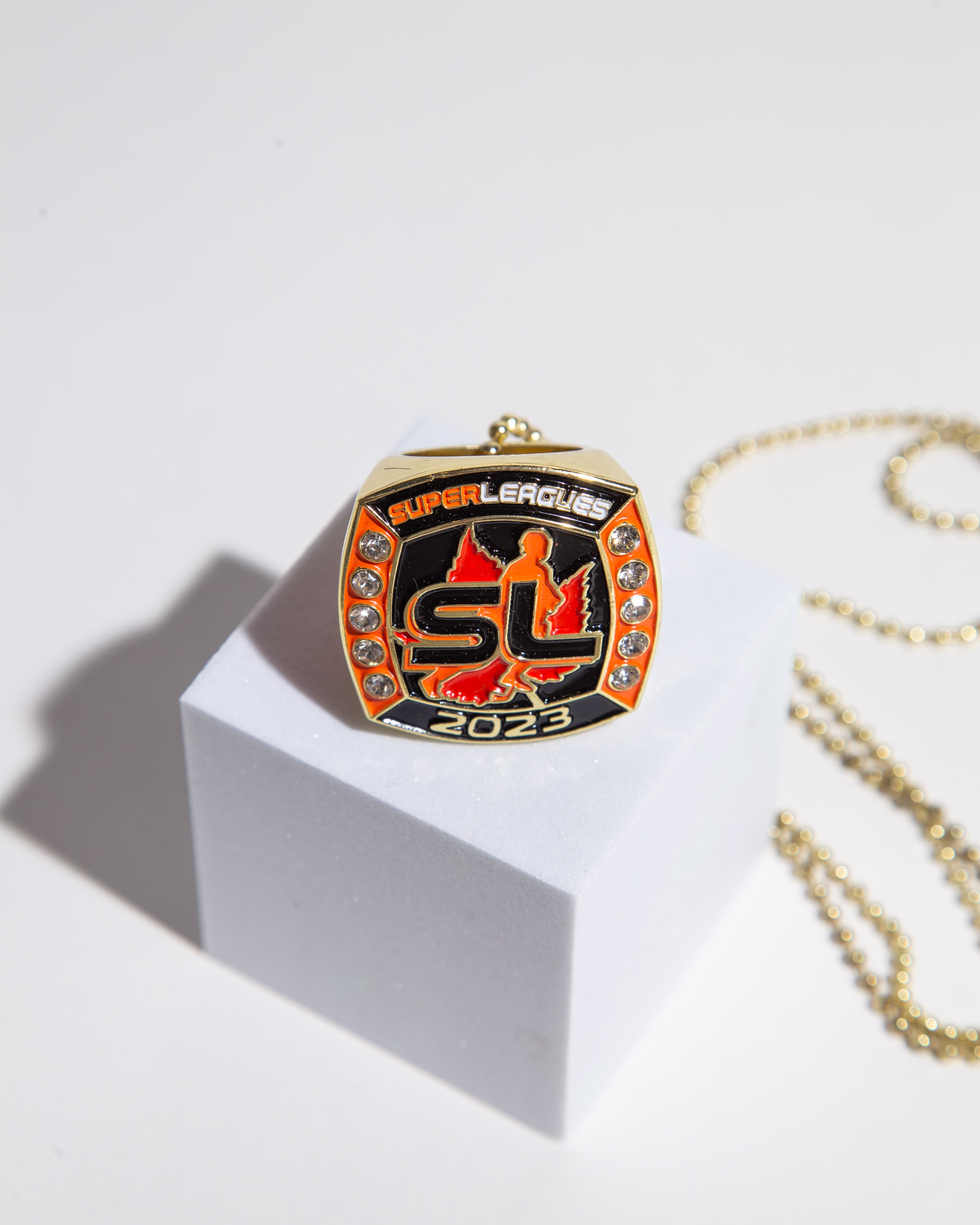 Custom Super Leagues 2023 championship ring featuring gold accents and vibrant orange highlights, designed for elite league winners.