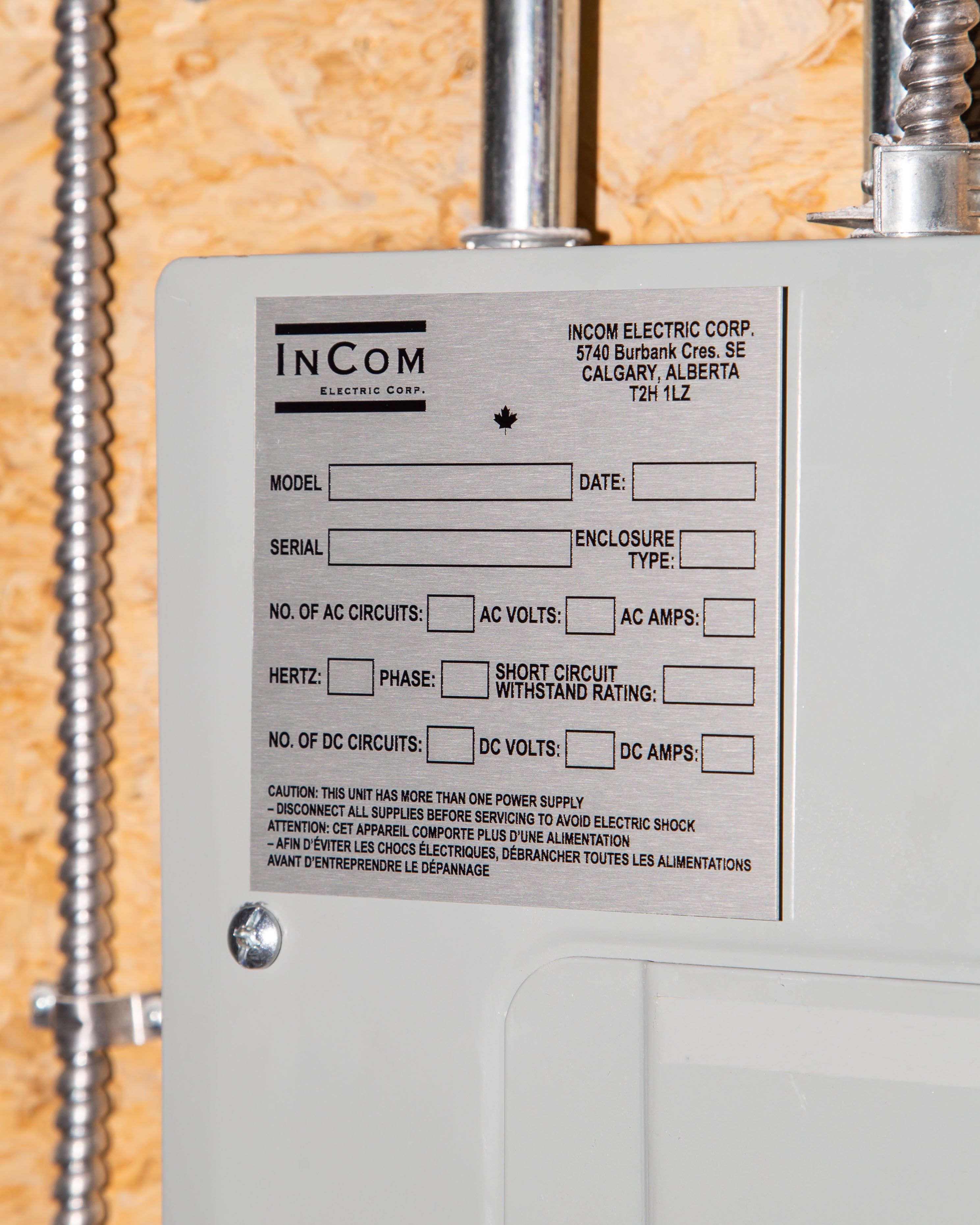 Close-up of an InCom Electric Corp panel label with technical specifications and safety warnings.