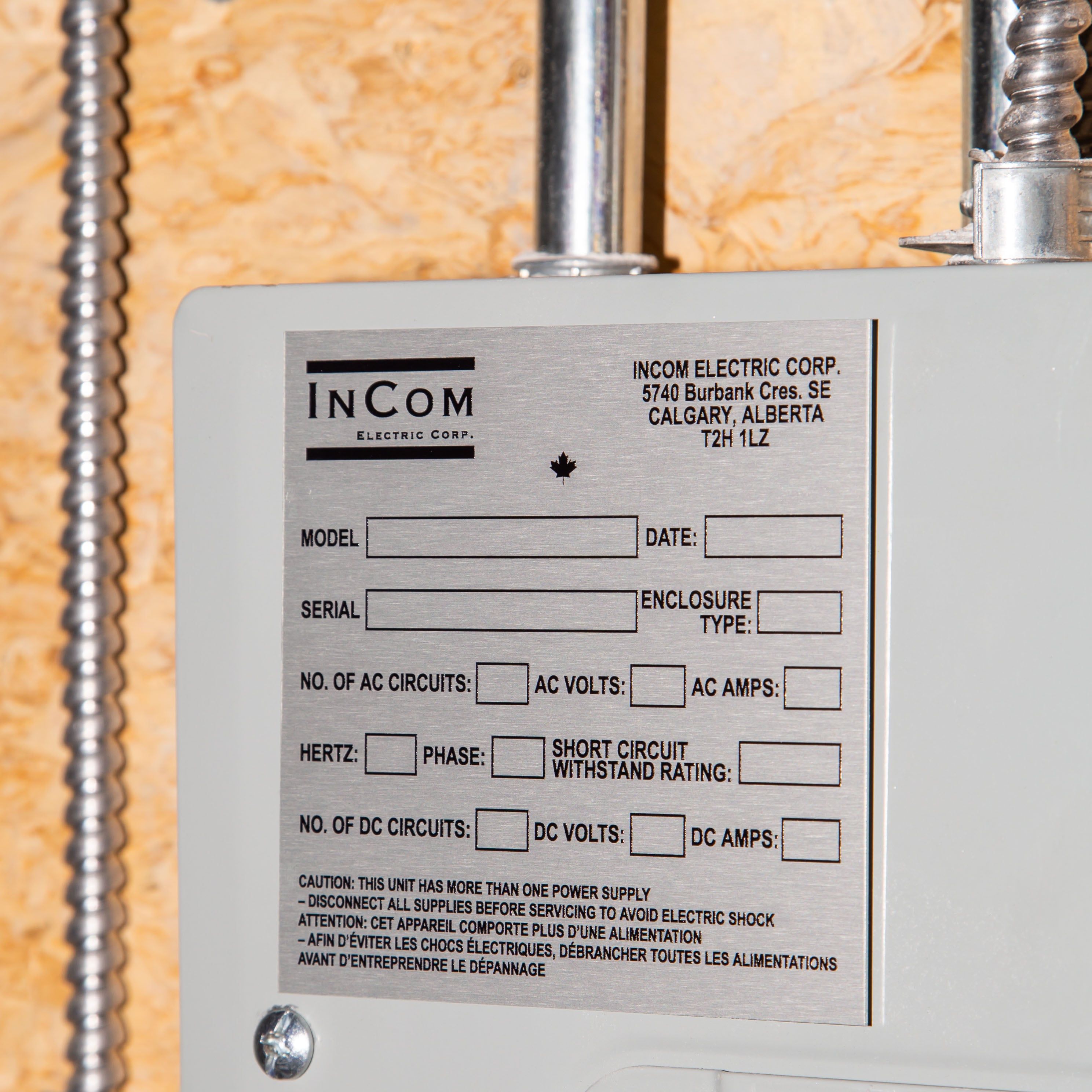 Close-up of an InCom Electric Corp panel label with technical specifications and safety warnings.