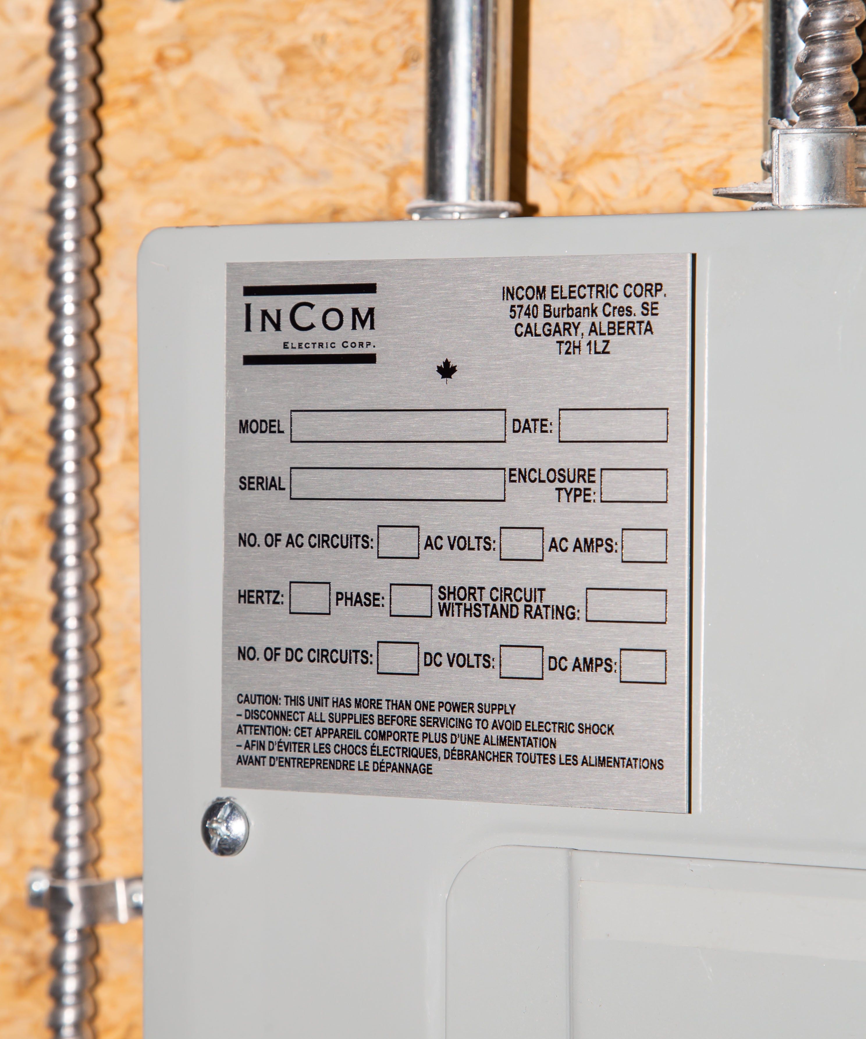 Close-up of an InCom Electric Corp panel label with technical specifications and safety warnings.