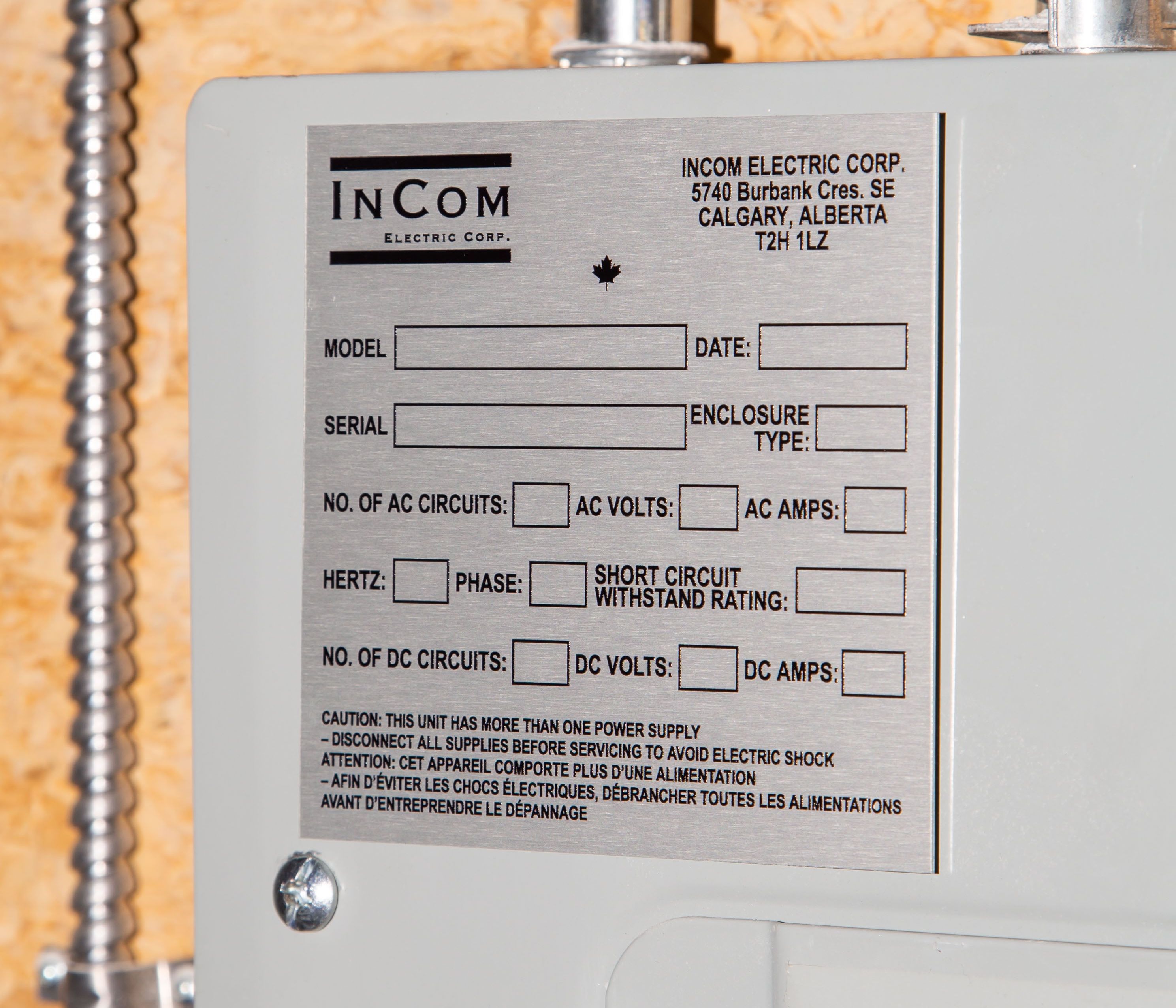 Close-up of an InCom Electric Corp panel label with technical specifications and safety warnings.