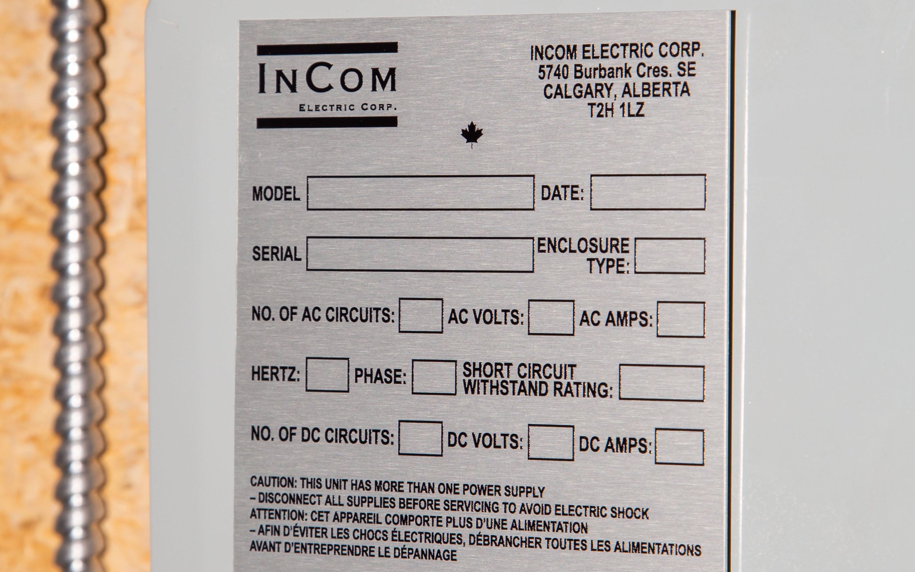 Close-up of an InCom Electric Corp panel label with technical specifications and safety warnings.