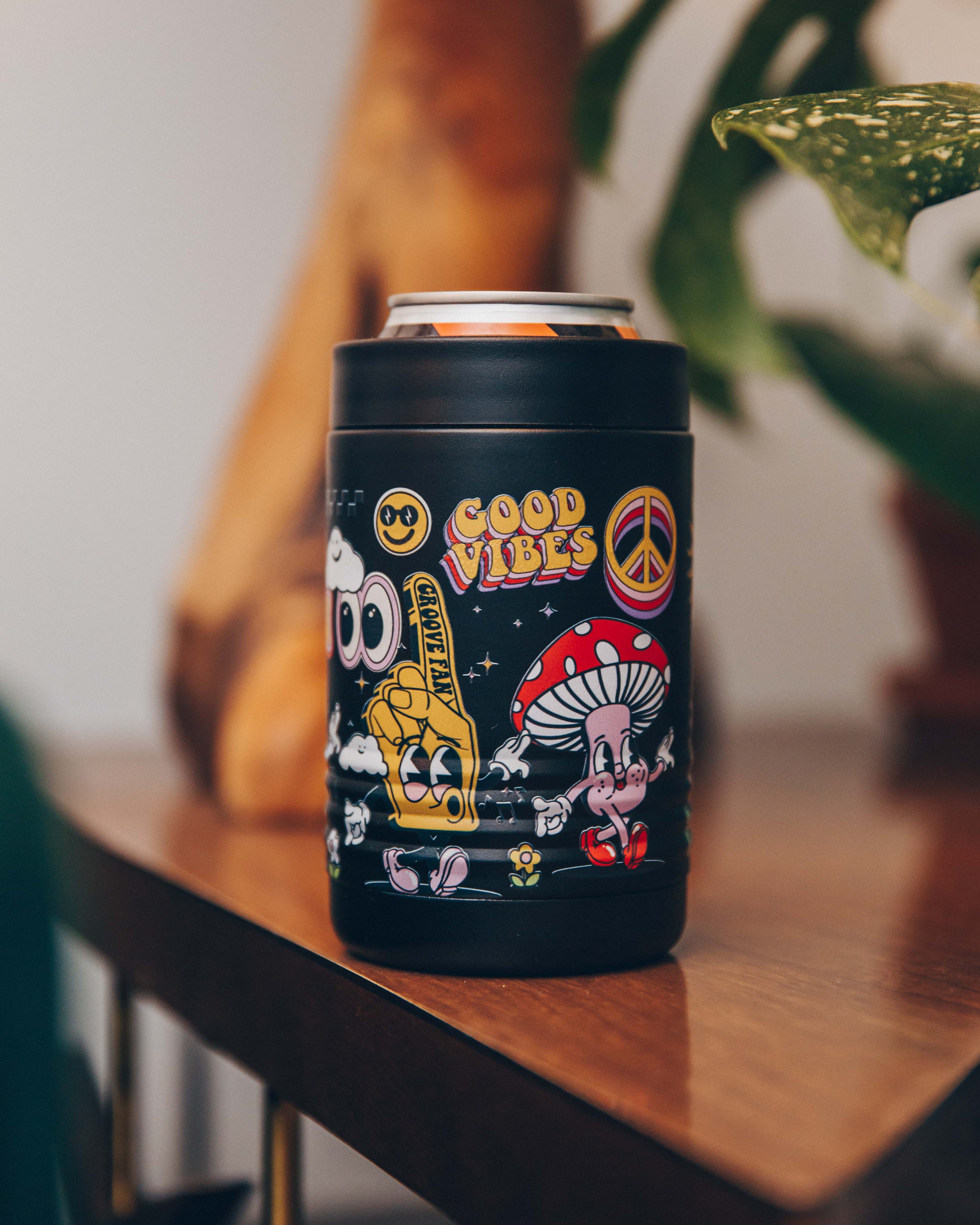 Black can holder with colorful retro designs and 'Good Vibes' text on a wooden table.