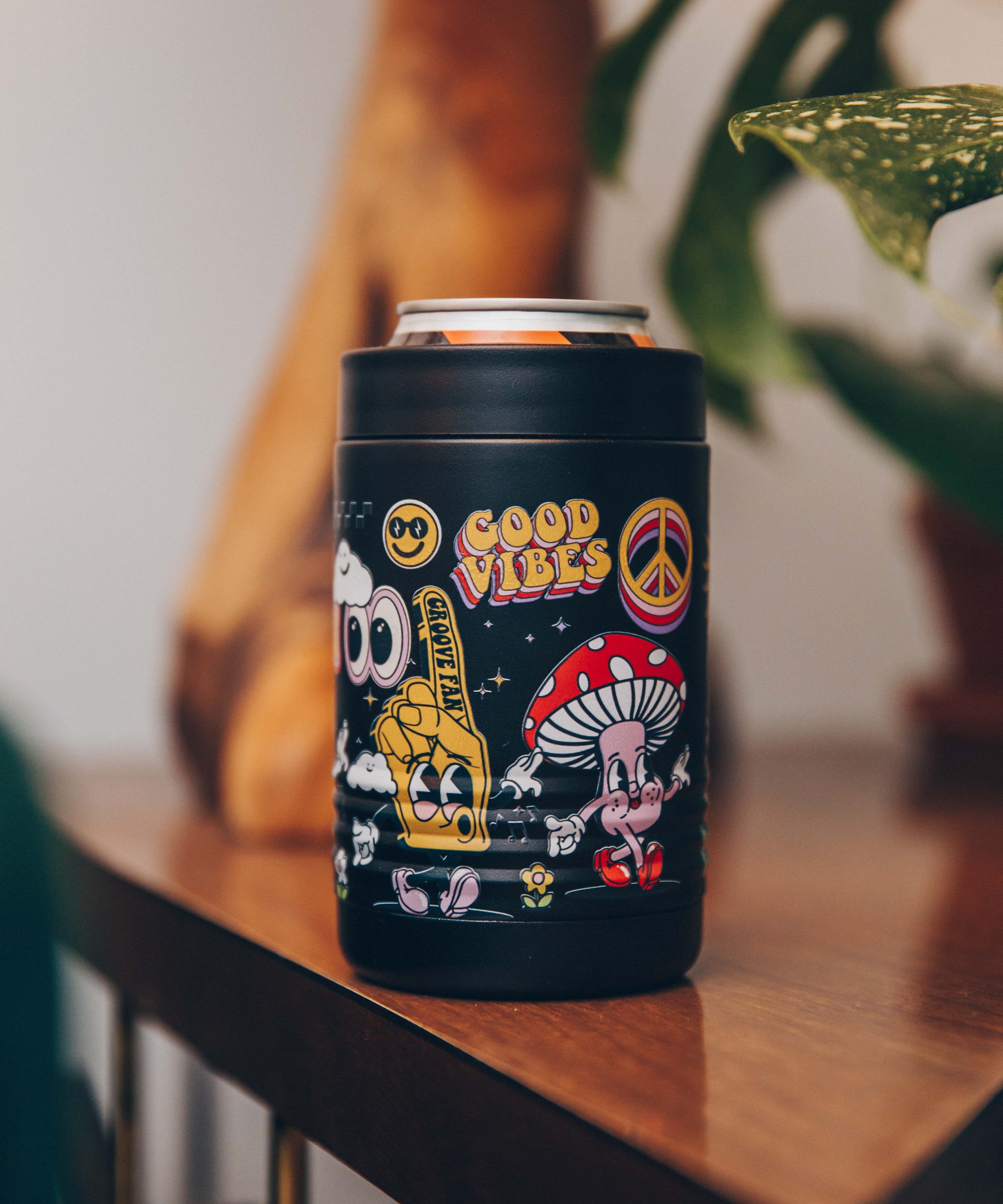 Black can holder with colorful retro designs and 'Good Vibes' text on a wooden table.