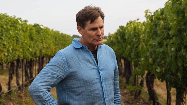 Photograph of a man standing in a vineyard