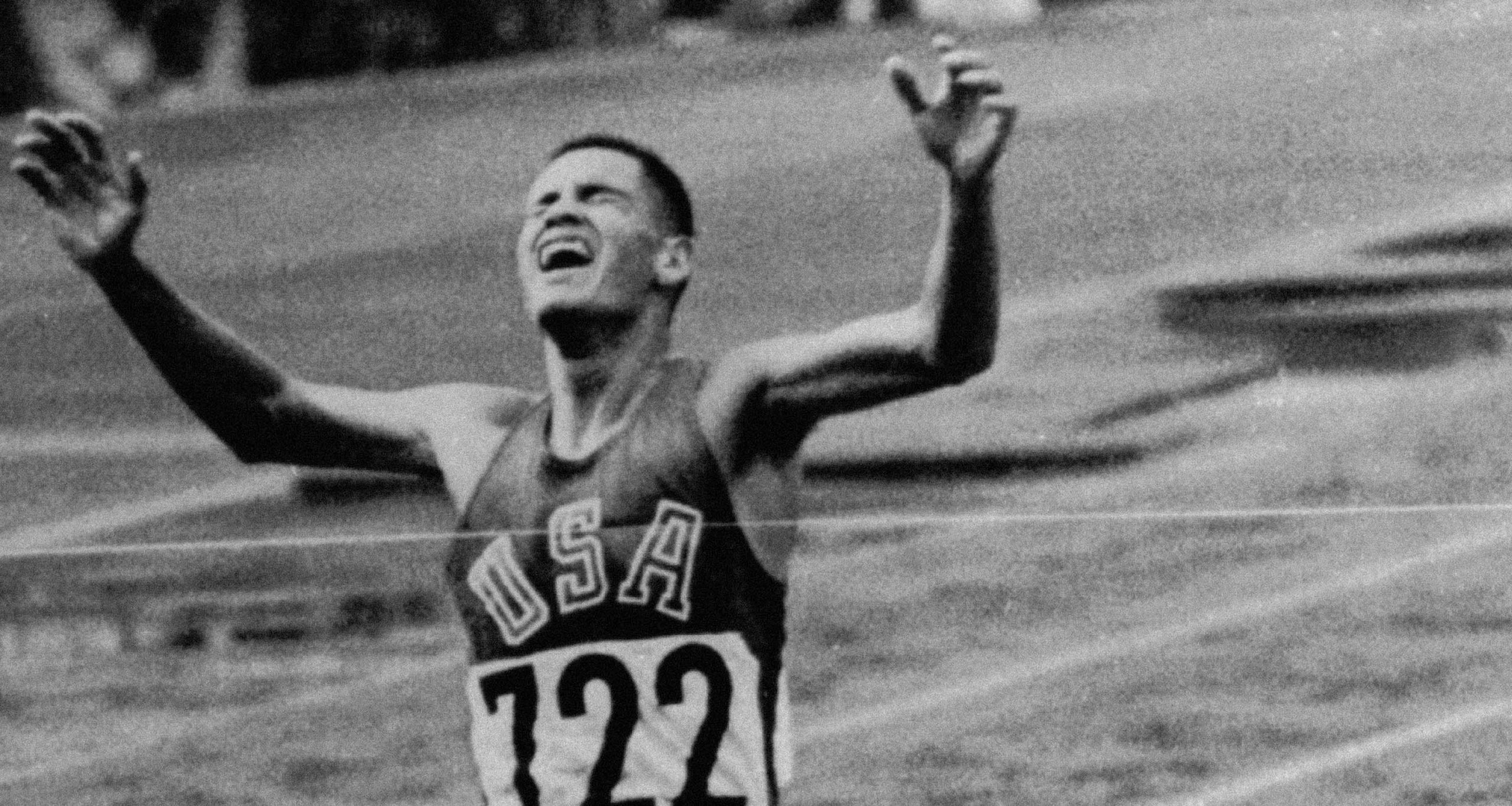 A track runner for Team USA crossing the finish line