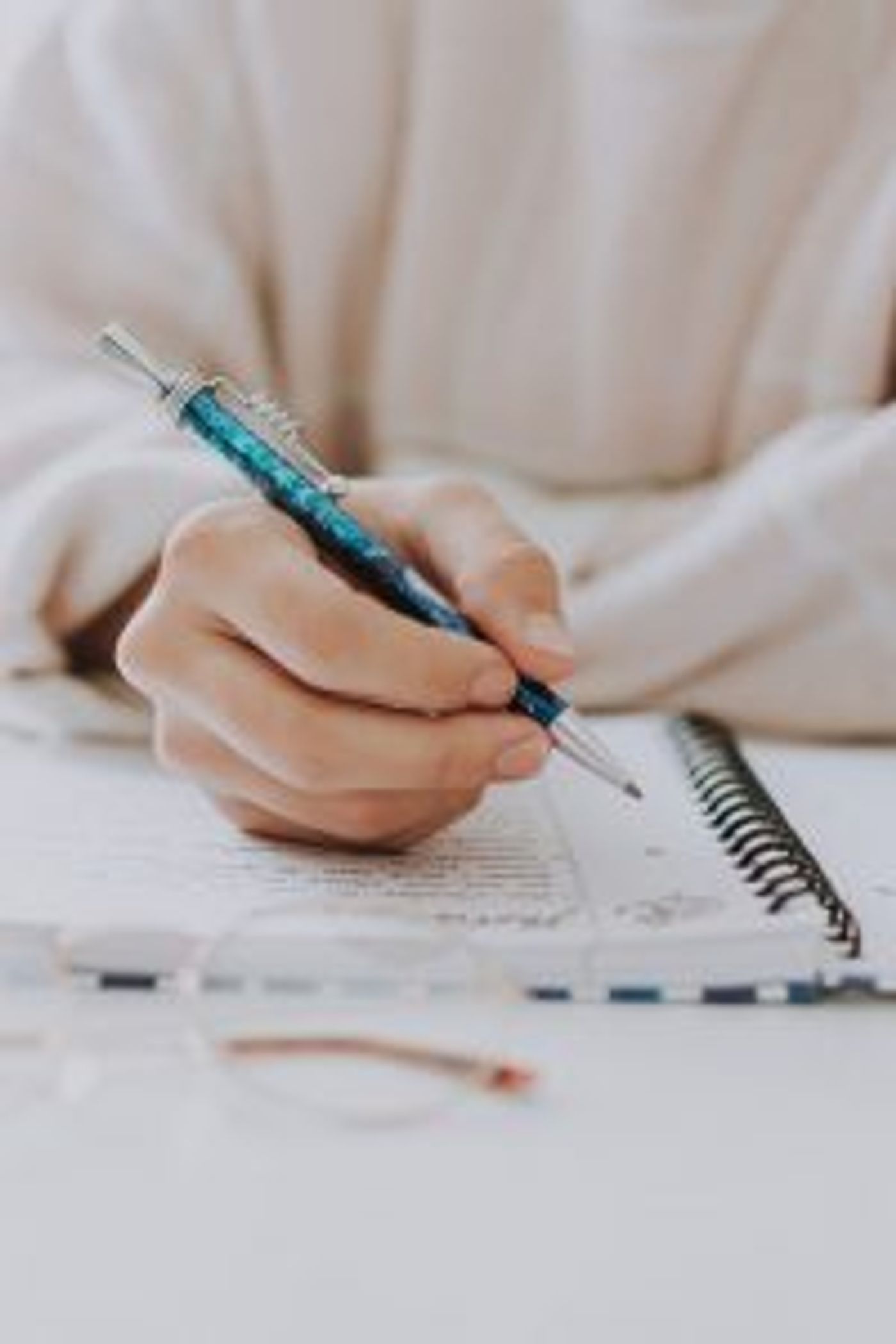 Hand mit Stift und ein Notzibuch