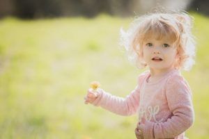 Kleines Kind mit Blume in der Hand