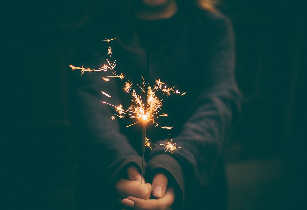Frau mit Wunderkerze in der Hand als Zeichen des Innehaltens