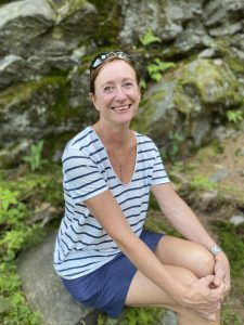 Portrait Alexandra Cordes-Guth der Wertschätzungscoach vor einem Felsen im sitzen