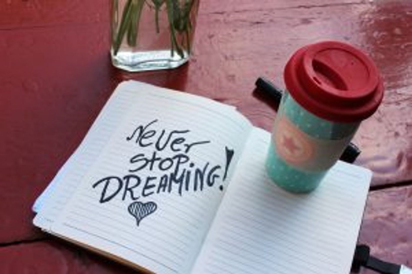 Heft in dem steht: Never stop dreaming mit einem Kaffeebecher