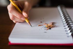 Notizblock und Hand mit Bleistift die schreibt