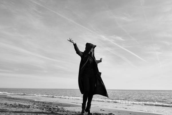 Junge Frau mit offenen Armen am Strand