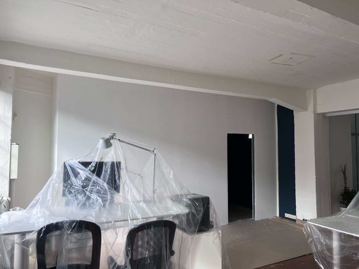 Nach den Arbeiten: die neue Wand ist geschlossen und gestrichen, die Möbel stehen noch unter Folie.