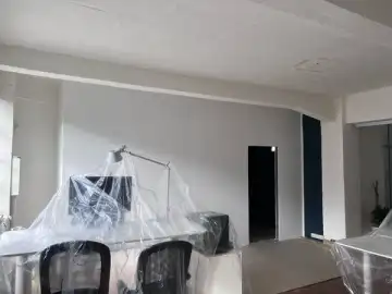 Nach den Arbeiten: die neue Wand ist geschlossen und gestrichen, die Möbel stehen noch unter Folie.