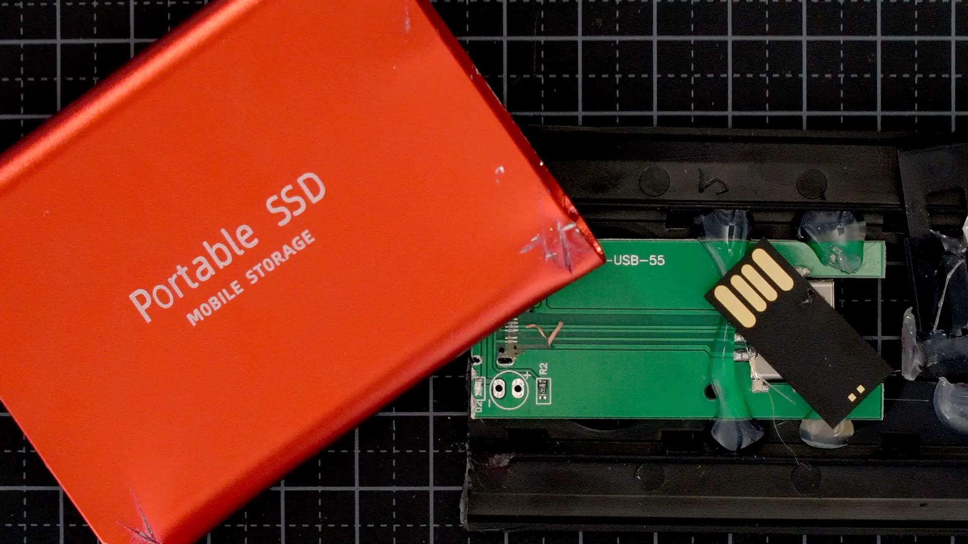 En falsk röd extern SSD-disk är uppbruten. På insidan syns att det inte är någon extern SSD-disk utan ett litet usb-minne.