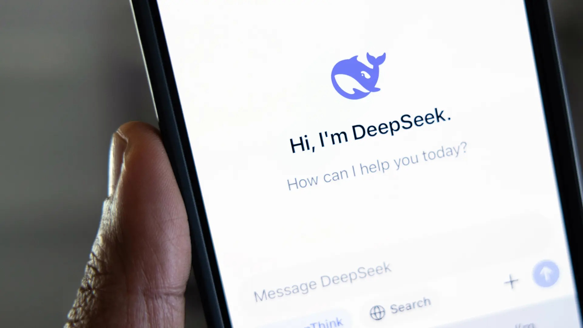 Användare håller en Iphone i handen. Deepseeks app visas på skärmen.