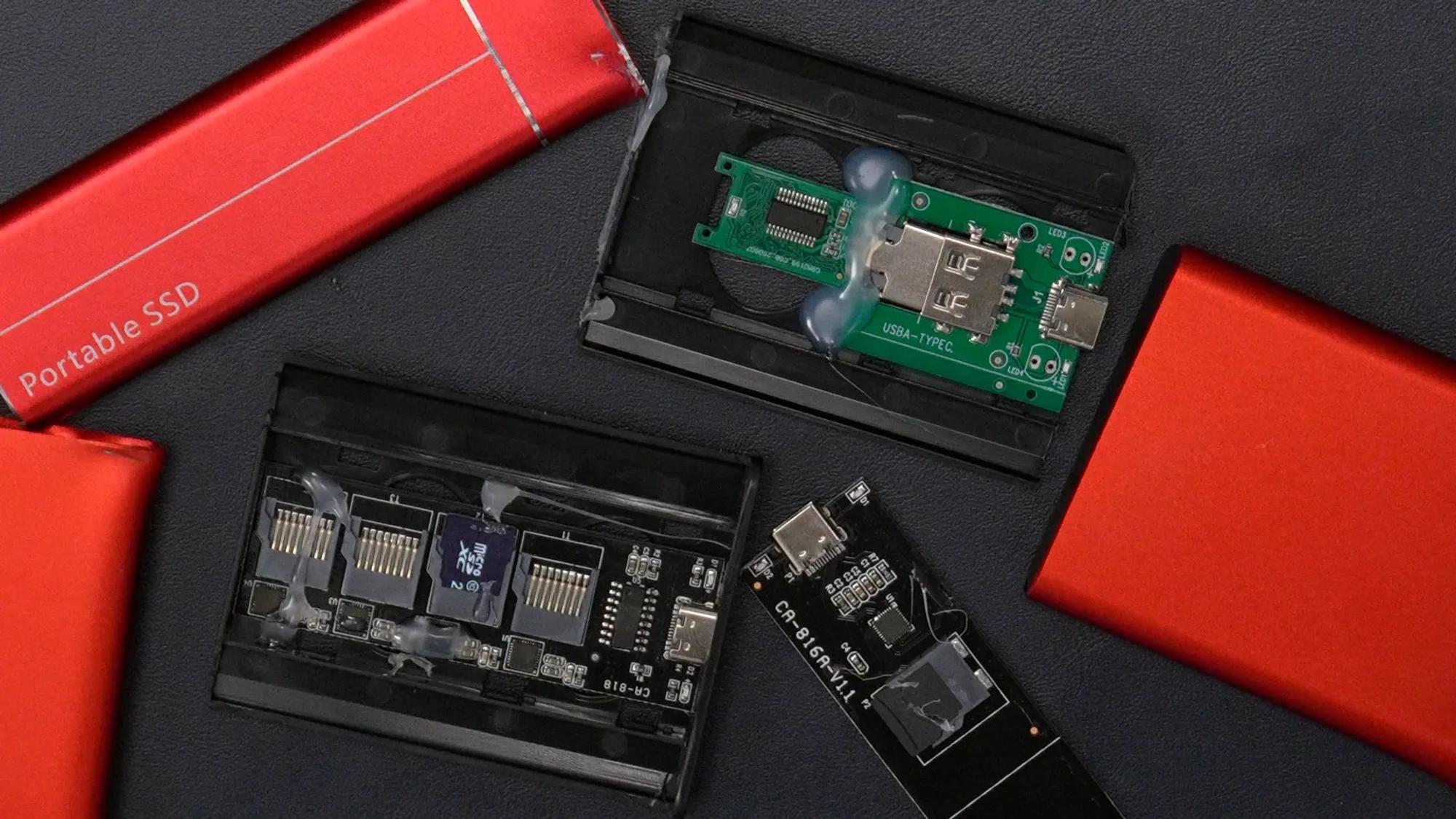 Tre röda ssd-diskar har brutits upp. På insidan syns kretskort med minneskortsläsare och adaptrar från usb-a till usb-c. 