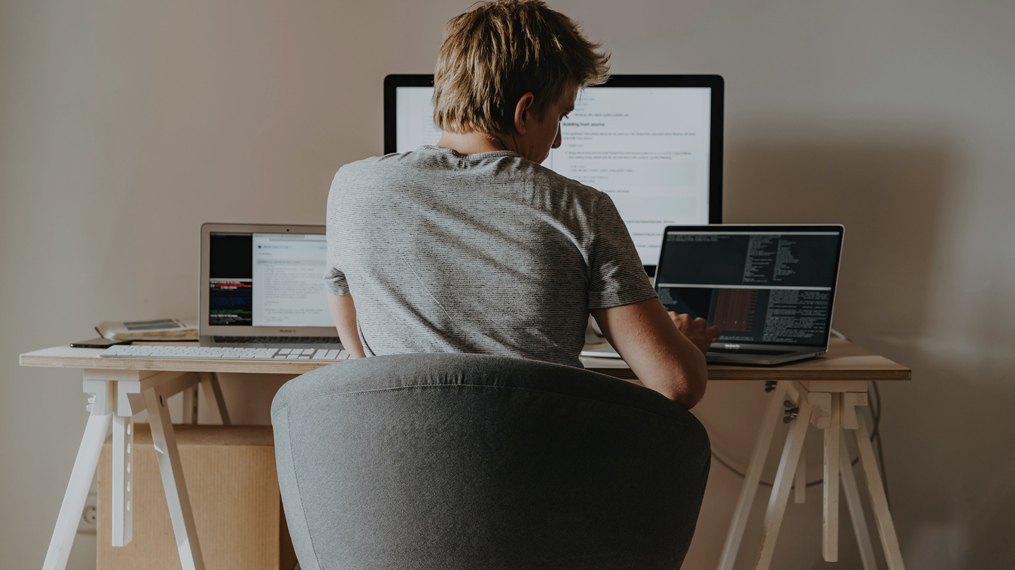 Kille som sitter vid ett skrivbord och jobbar hemifrån.