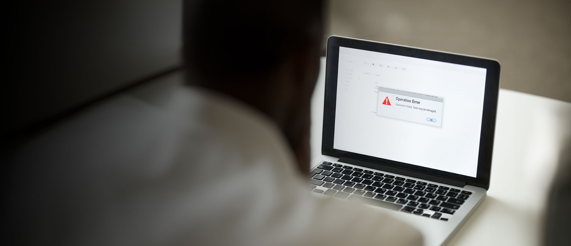 man sitter framför laptop och besöker falsk hemsida